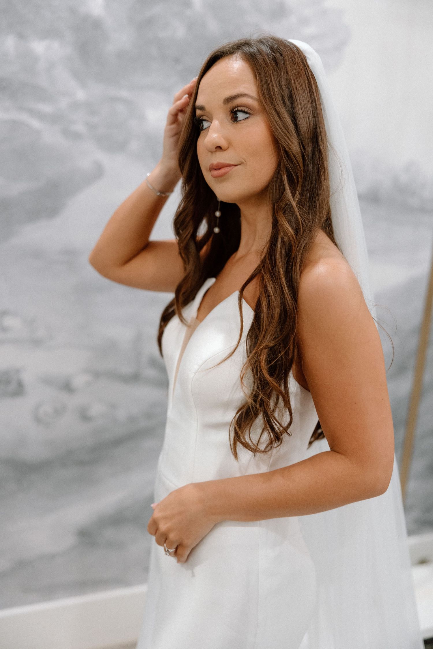 A woman in a white dress poses gracefully against a cloudy backdrop in a series of elegant portraits.