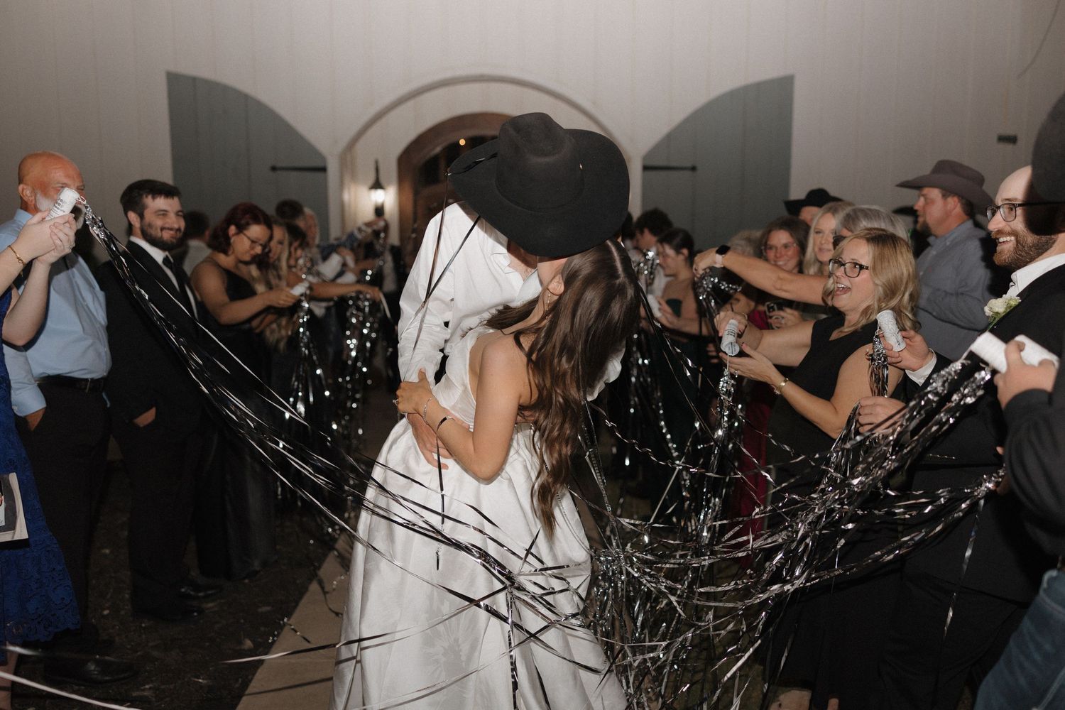 People dancing and celebrating at a nightclub party with confetti and strobe lights.
