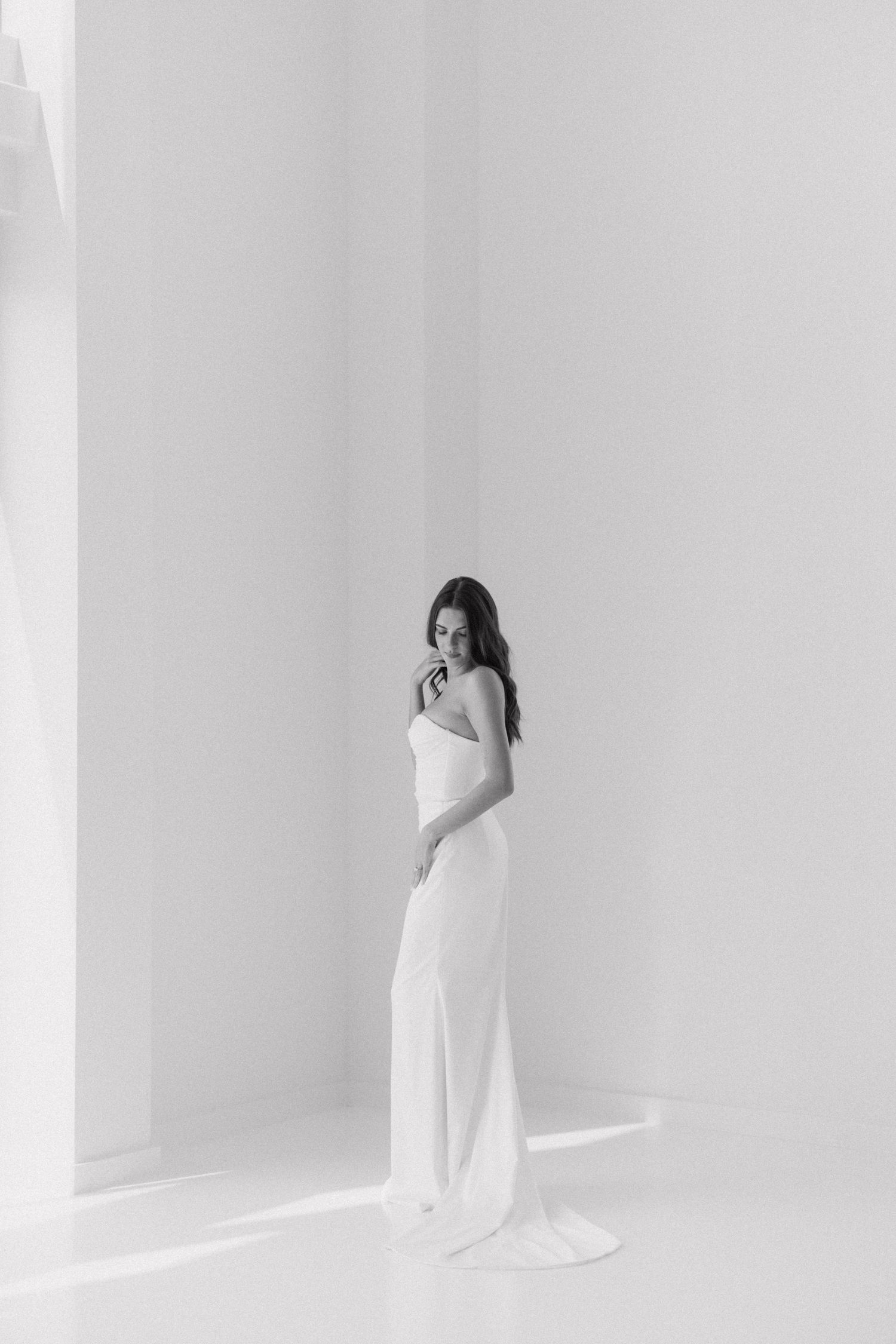 Minimalist bridal portraits against white wall showing elegant poses and movement.