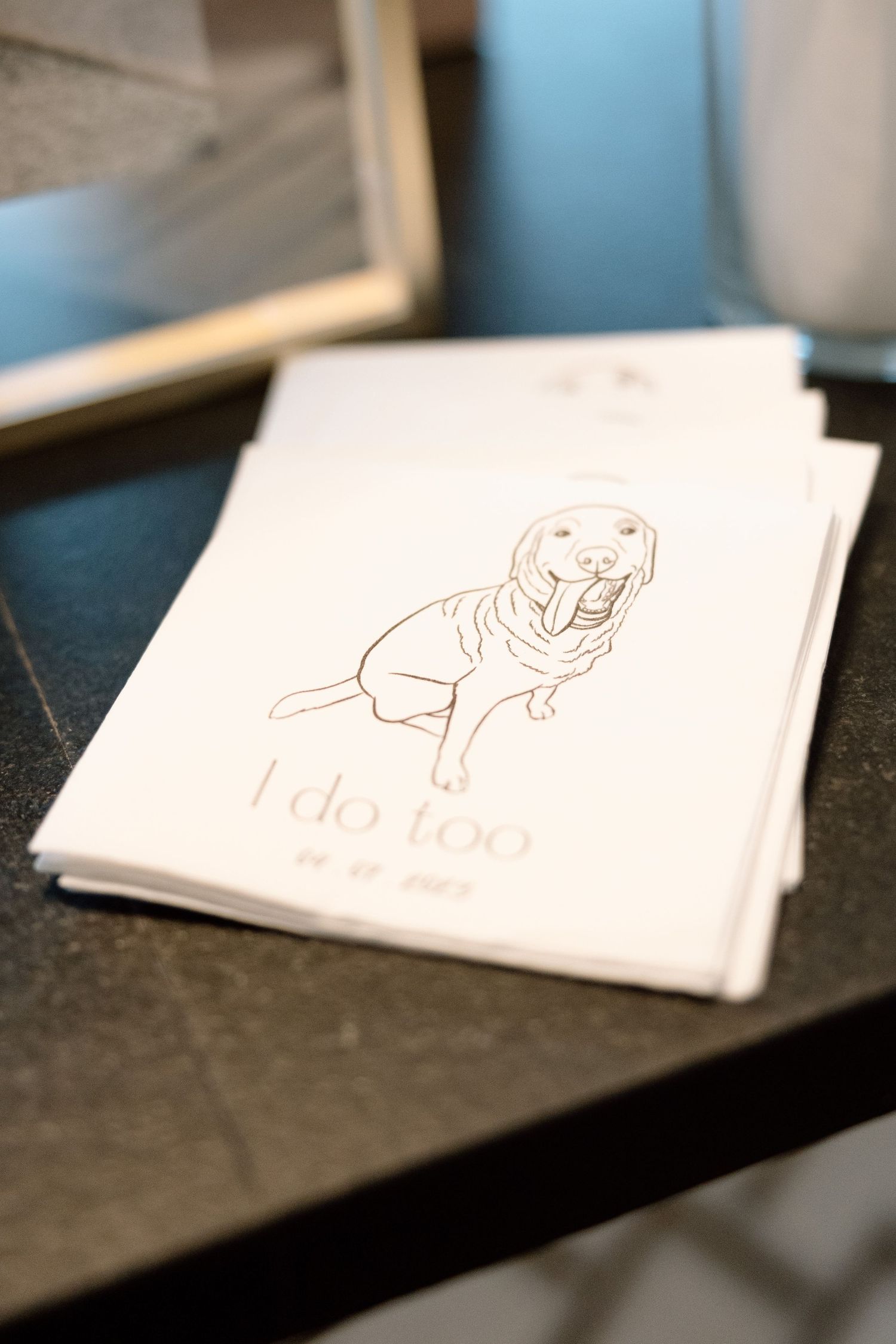 A sequence of business cards shown at different angles on a dark surface, displaying simple line drawings and minimal design.