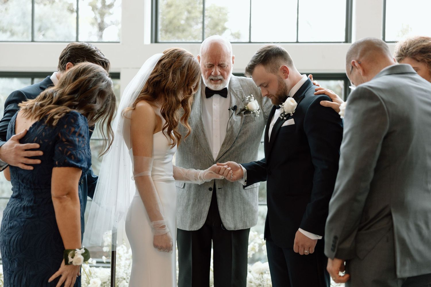 Wedding reception line of guests hugging and greeting each other in formal attire.