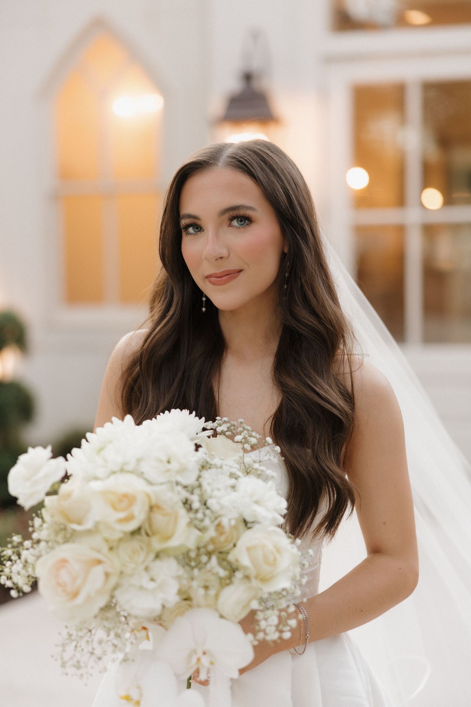 A bridal portrait series featuring a white wedding bouquet with roses and baby's breath against an elegant white backdrop.