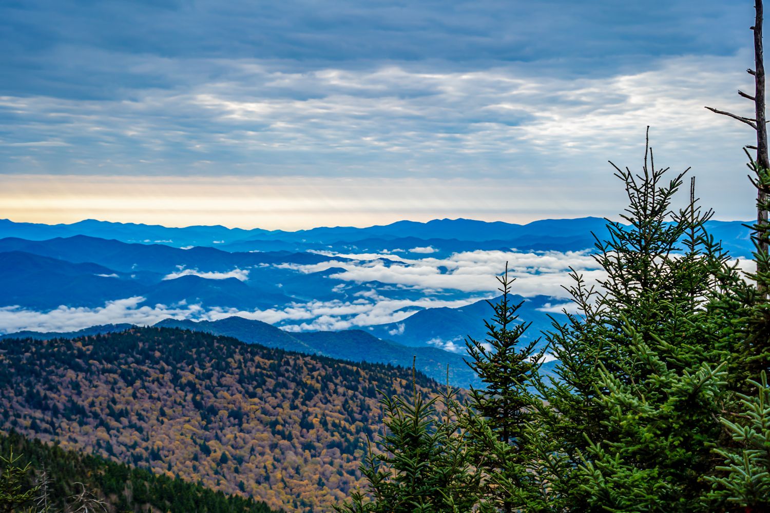 Aerial view of Great Smoky Mountains with clouds filling valleys at dawn.