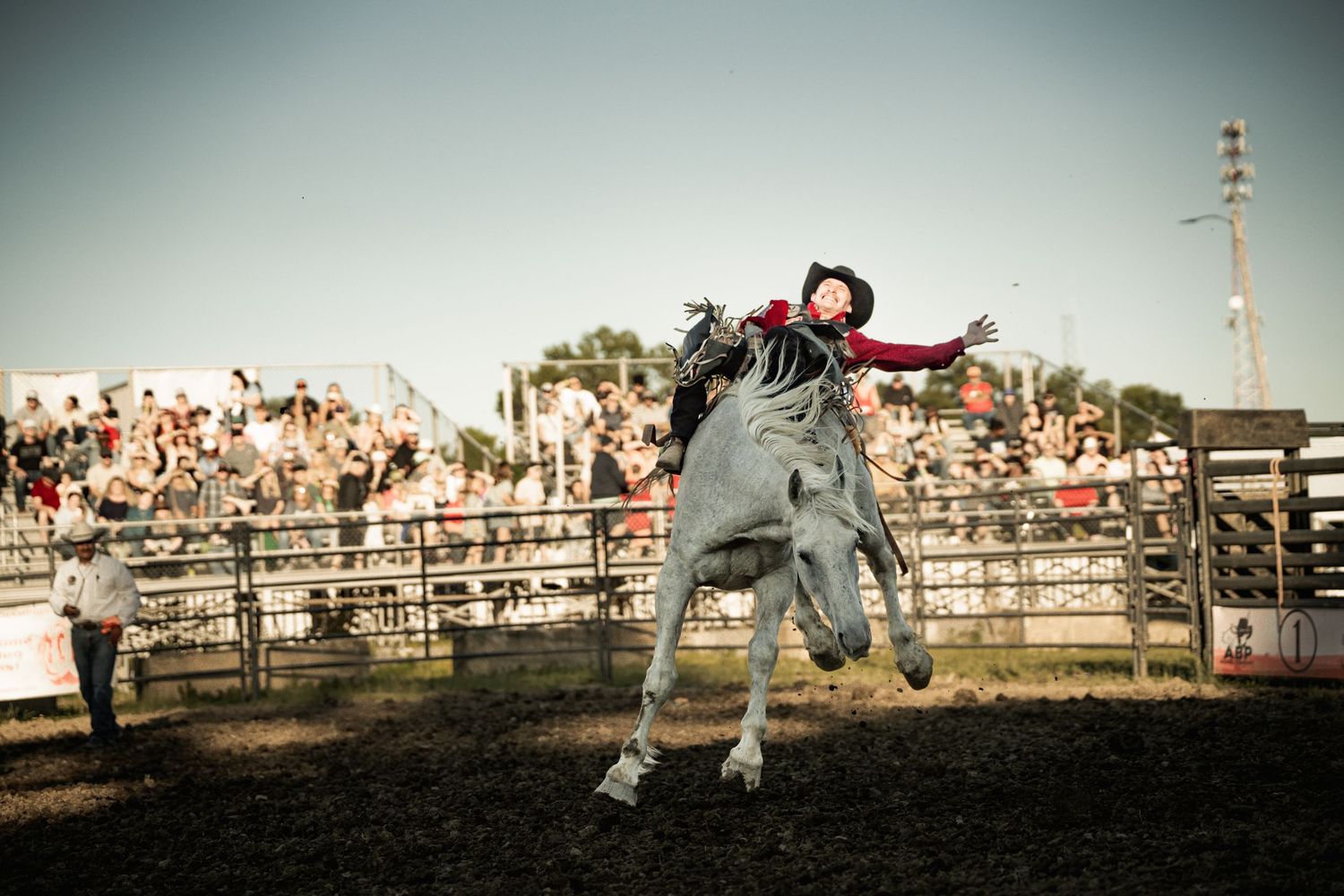 A bull rider holds on as a bucking bull leaps high in the air during an exciting rodeo competition.