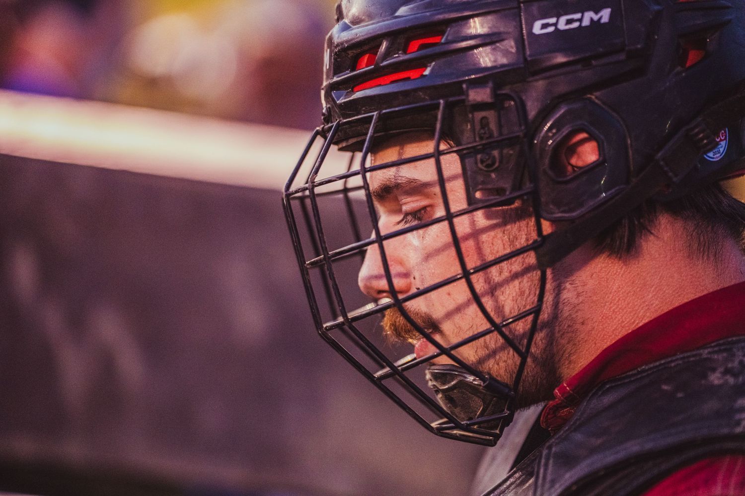 Close-up of a hockey player wearing a CCM helmet with cage face guard during a game.