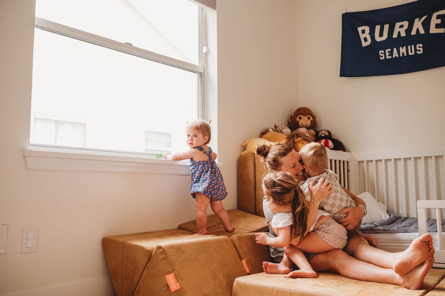 Children playing on moving boxes in a bright room during an in-home photo session in Orlando fl