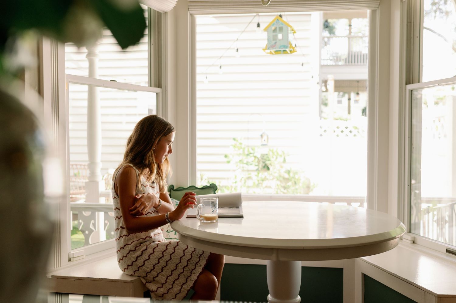 girl sitting by windows reading during an in-home photoshoot in orlando Florida