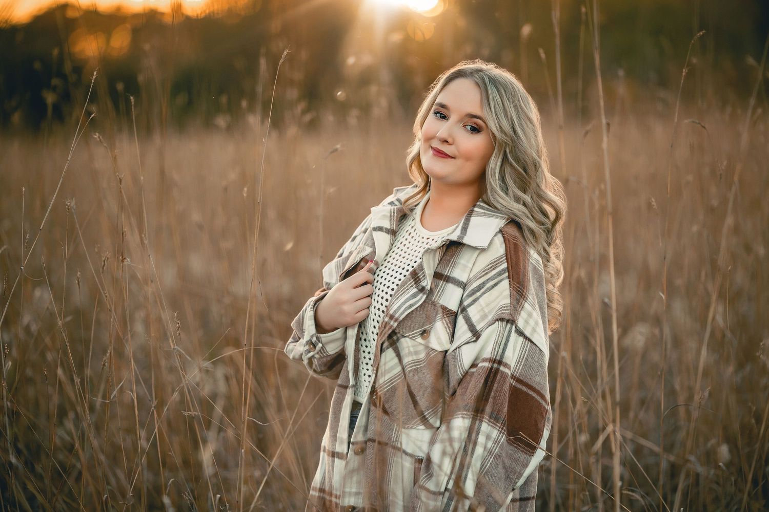 Autumn portrait in plaid shacket during golden hour in tall grasses.