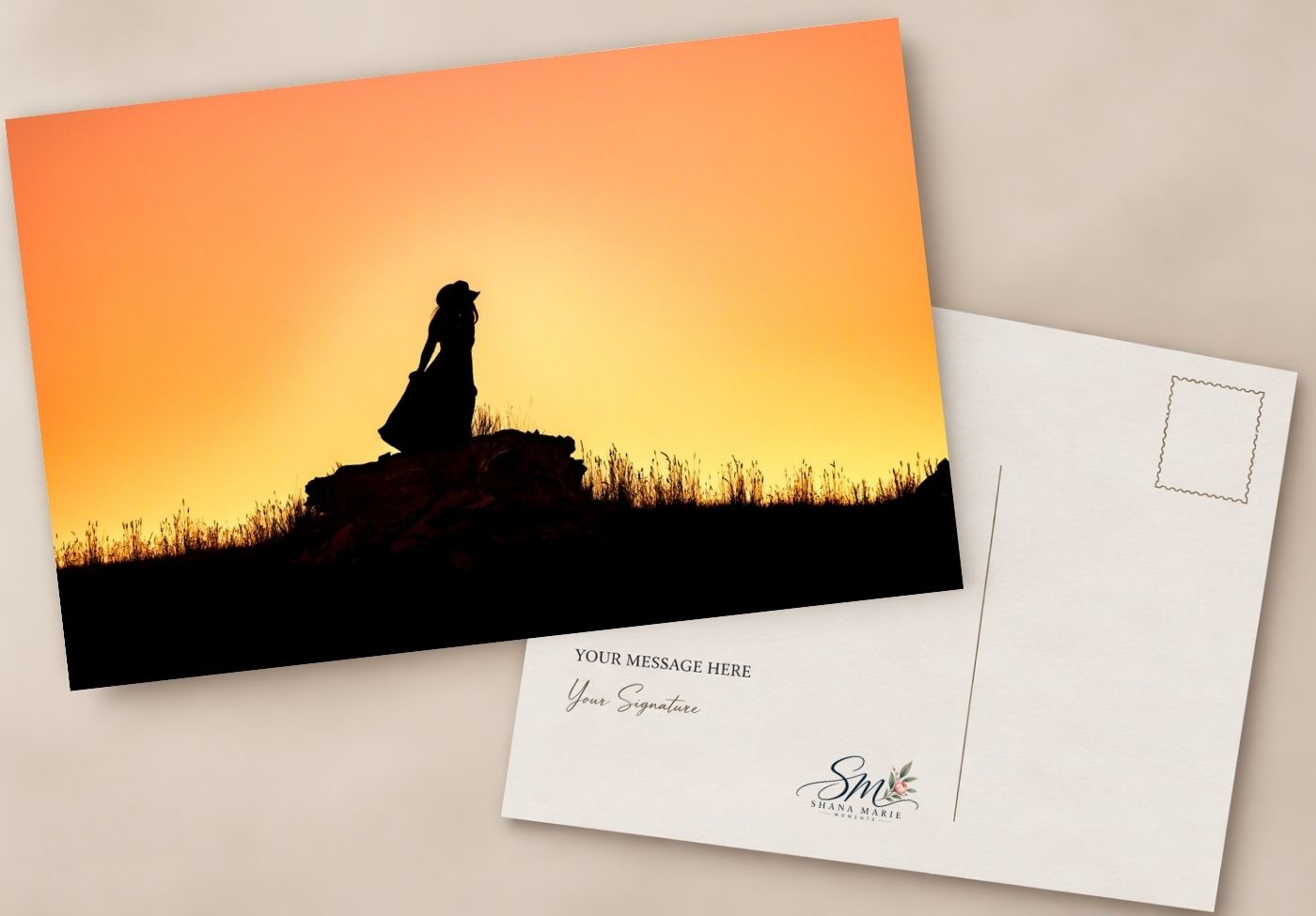 Silhouette postcard of a woman sitting on rocks at sunset with golden orange sky, featuring a blank message area on the back.