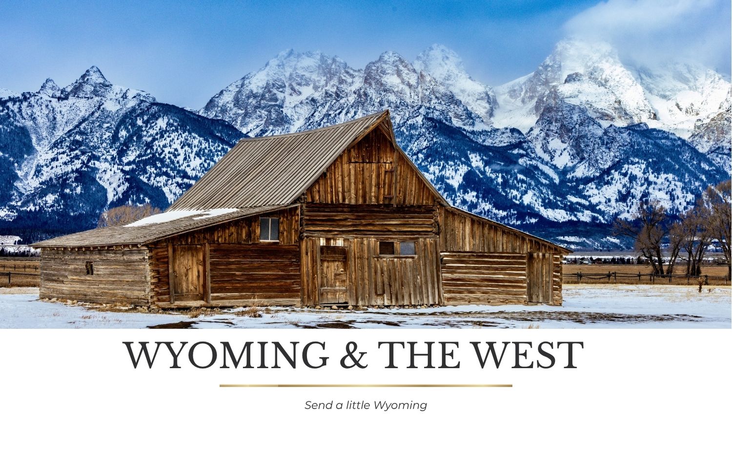 Rustic wooden barn in Grand Teton National Park with snow-capped mountains in Wyoming winter landscape.
