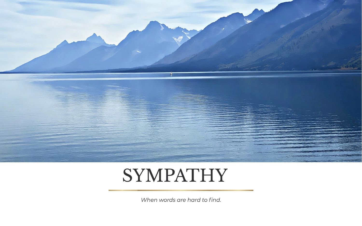 Sympathy card featuring serene mountain lake landscape with misty blue peaks reflected in calm water.
