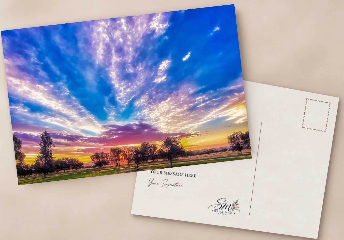 Postcard featuring a vibrant sunset sky with purple and blue hues over a green landscape, with a blank message area on the reverse.