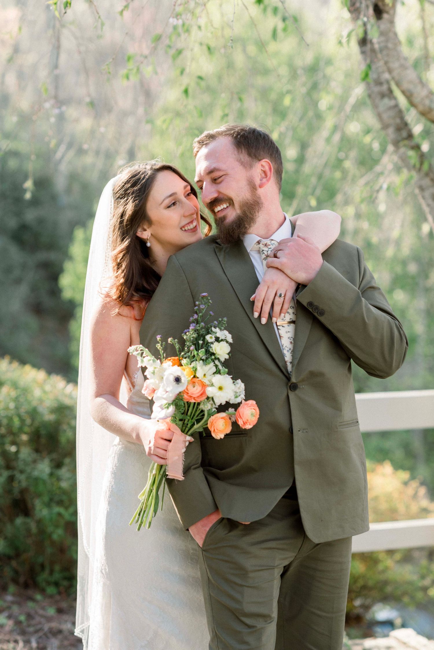 Romantic wedding couple sharing intimate moments with floral bouquet in an outdoor setting.