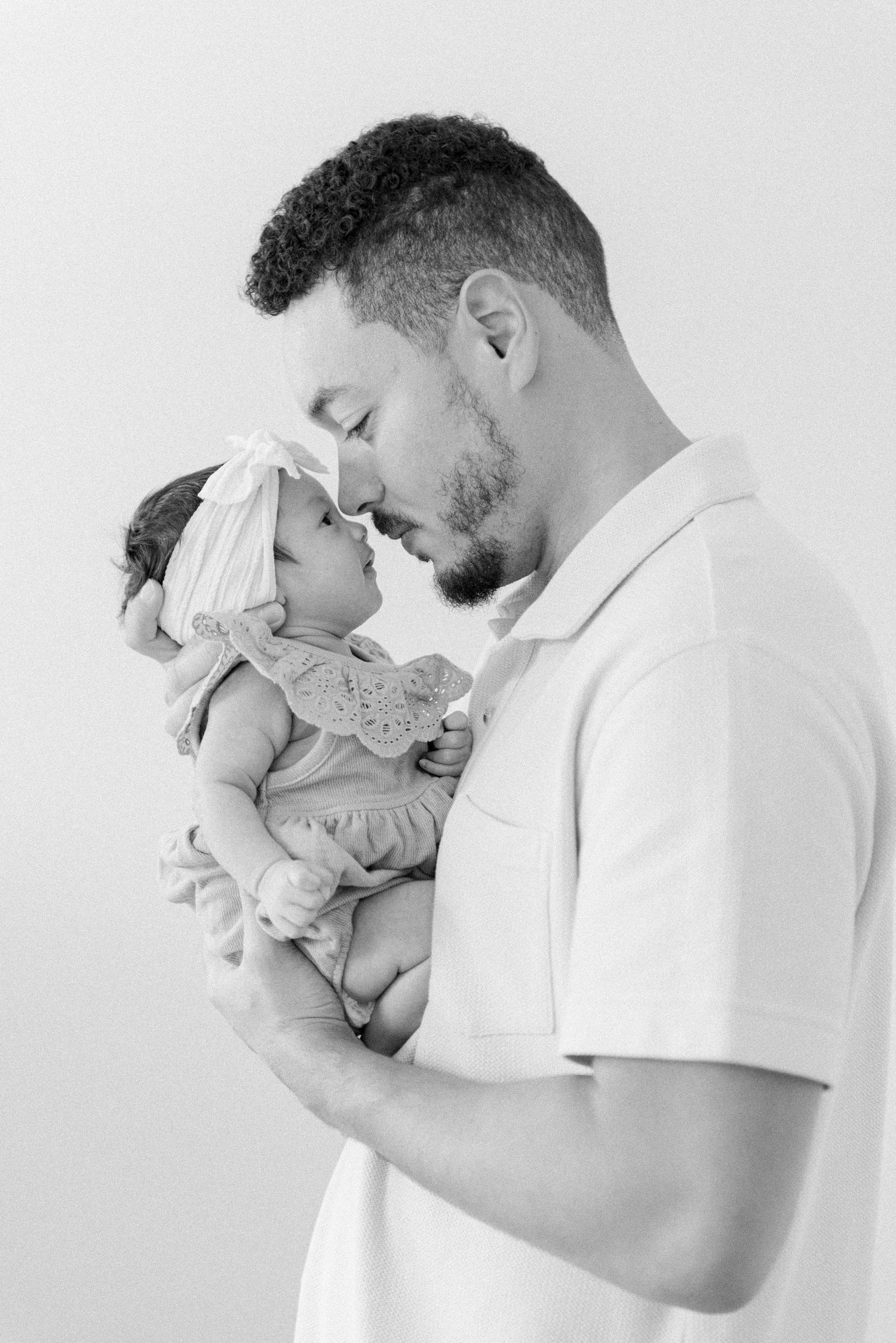 Black and white photos of tender moments with a newborn baby.