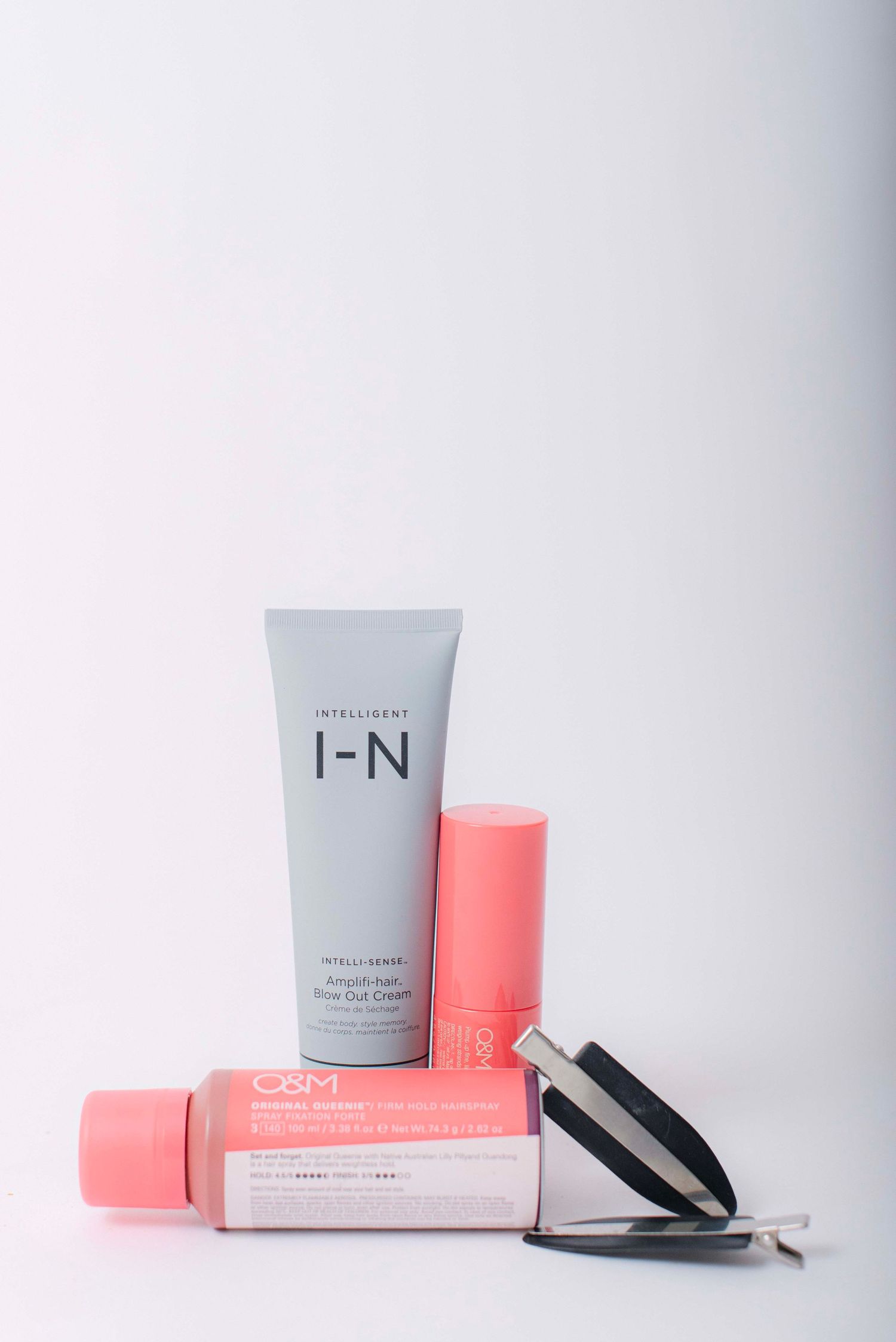 Minimalist product photography of skincare items in gray and coral pink packaging.