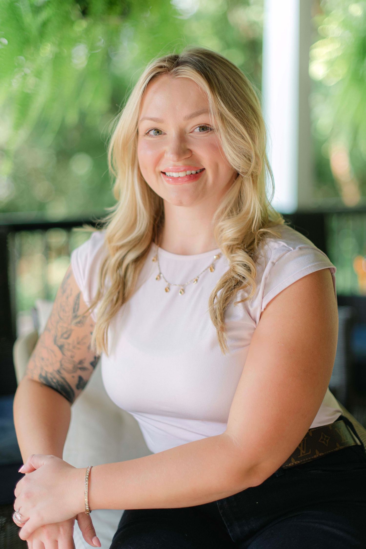Portrait series showing a person in a white sleeveless top with tattoos against a blurred green background.