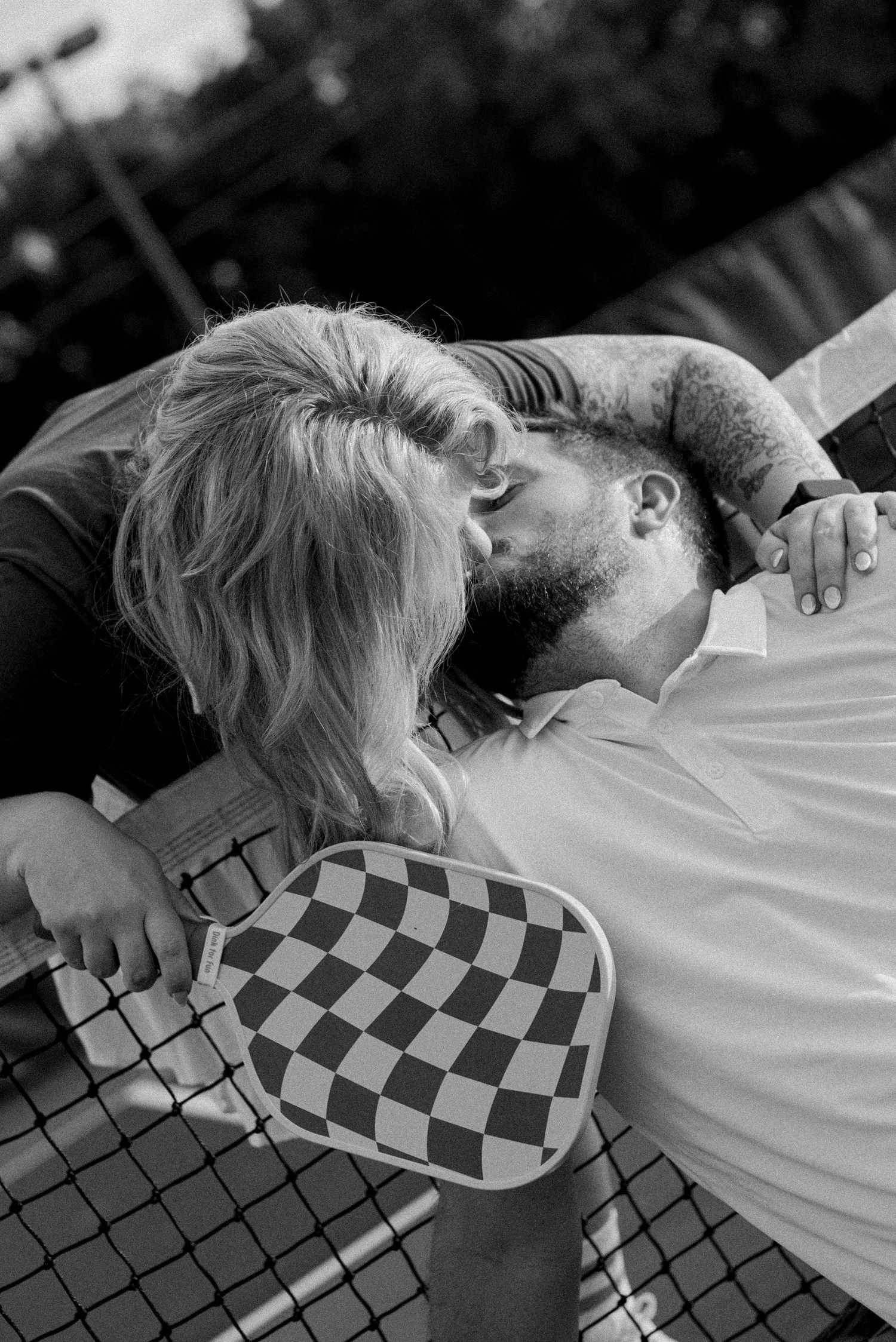 A sequence of black and white photos showing two people in an intimate embrace wearing checkered clothing.