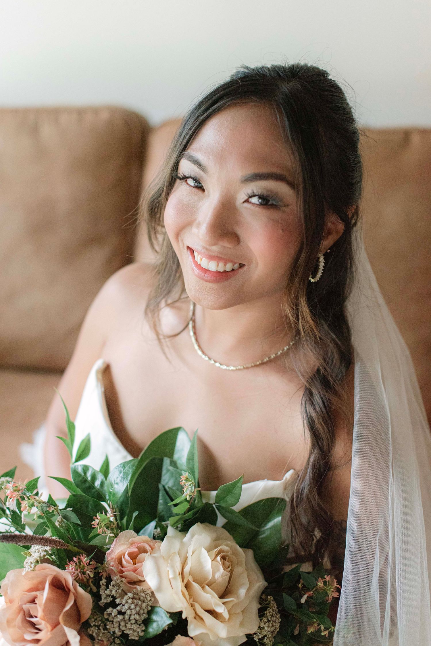 A bride poses with a peach and cream floral bouquet in a series of close-up wedding portraits.