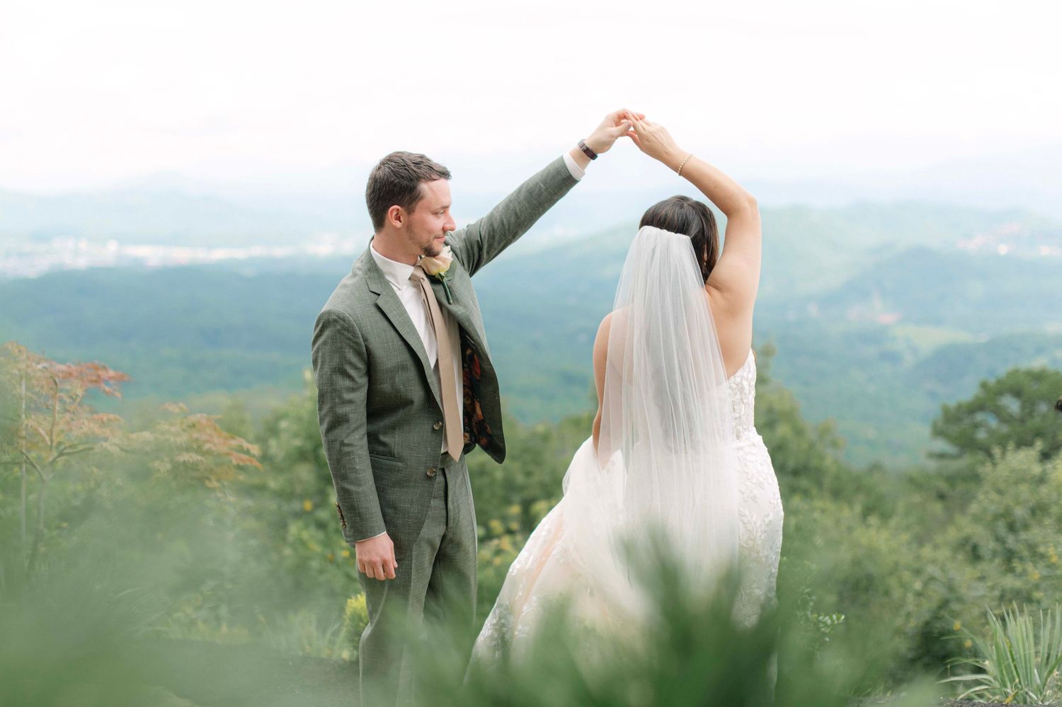 Couple dances together against a scenic mountain backdrop during their wedding celebration.