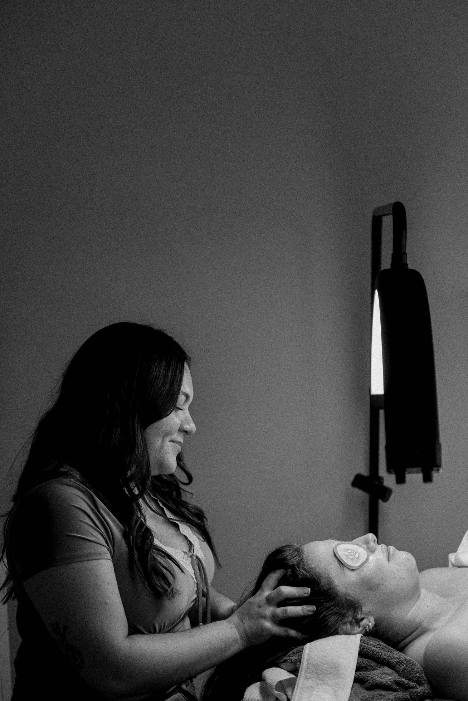 Side profile silhouette of spa treatment session in dim lighting.