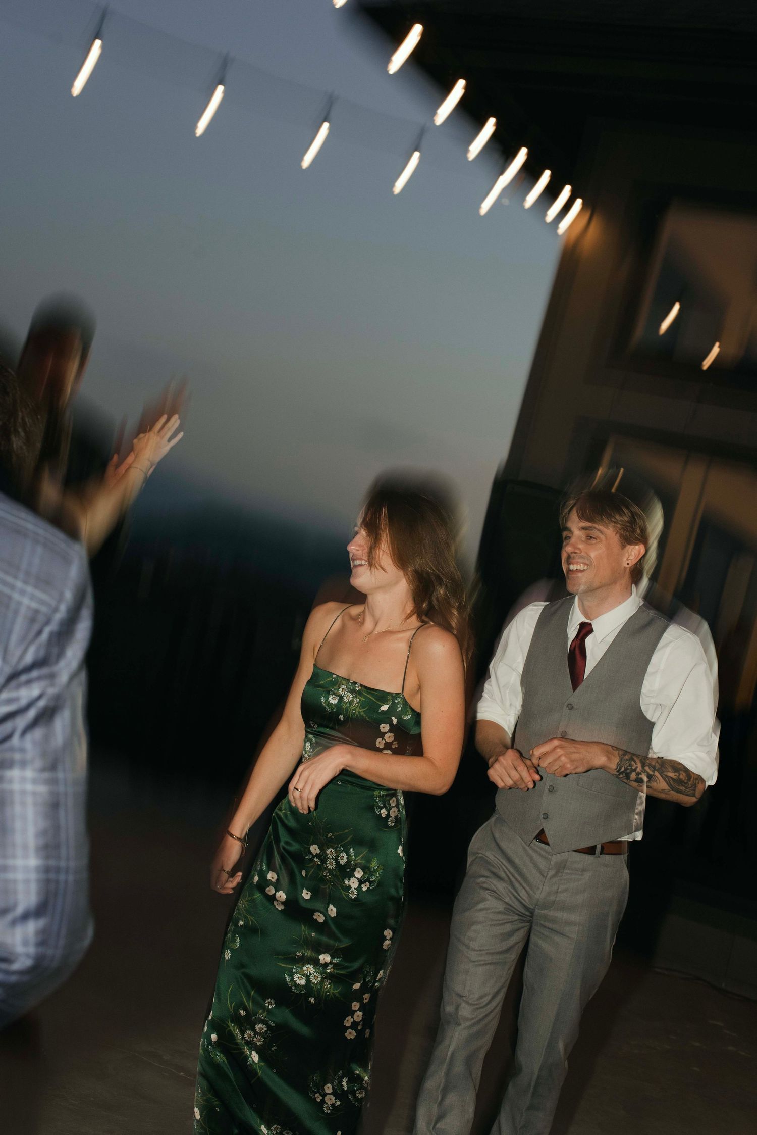 Wedding guests dancing and celebrating in formal attire at an evening reception.
