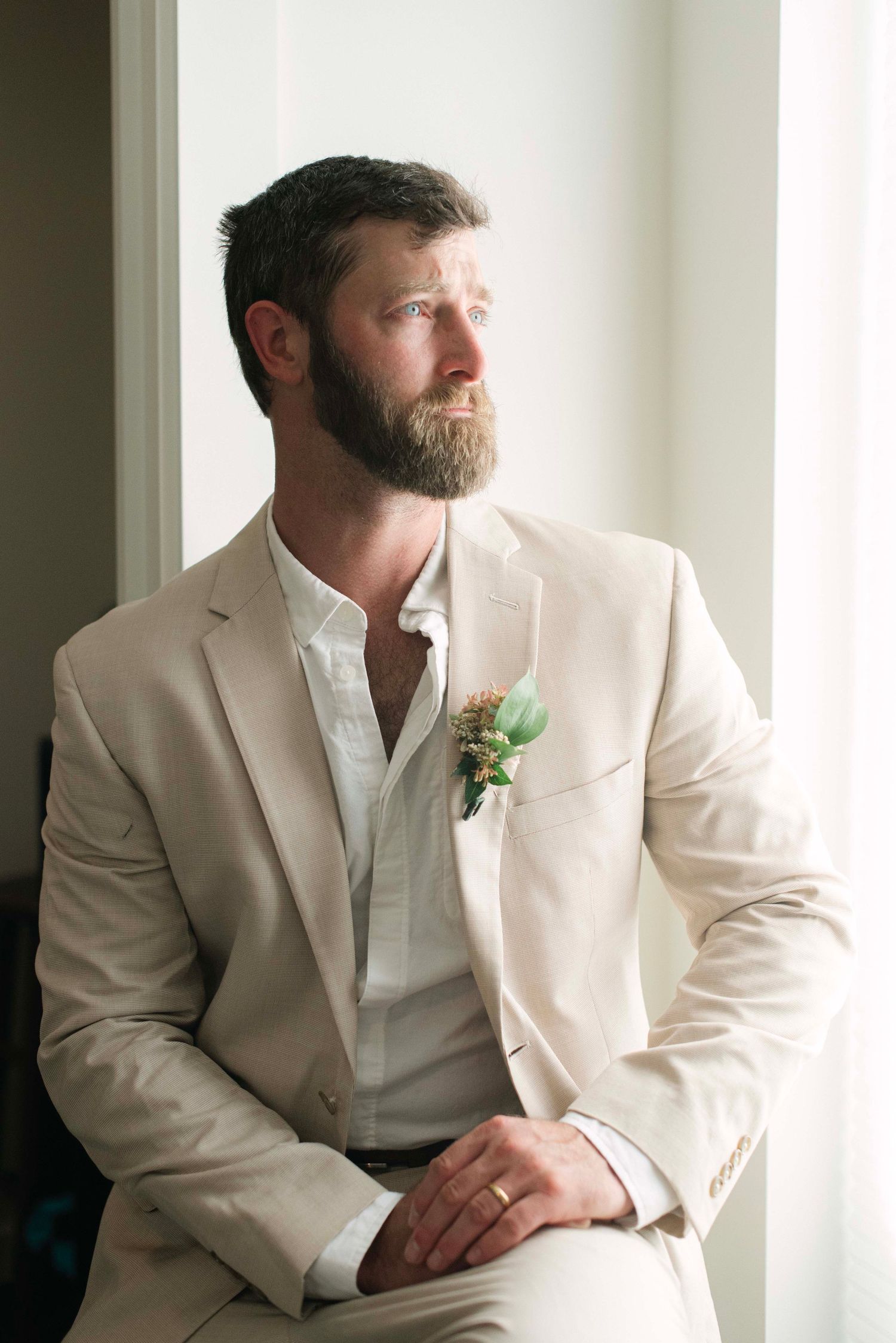 A collection of portraits showing someone in a cream suit and white shirt sitting by a window.