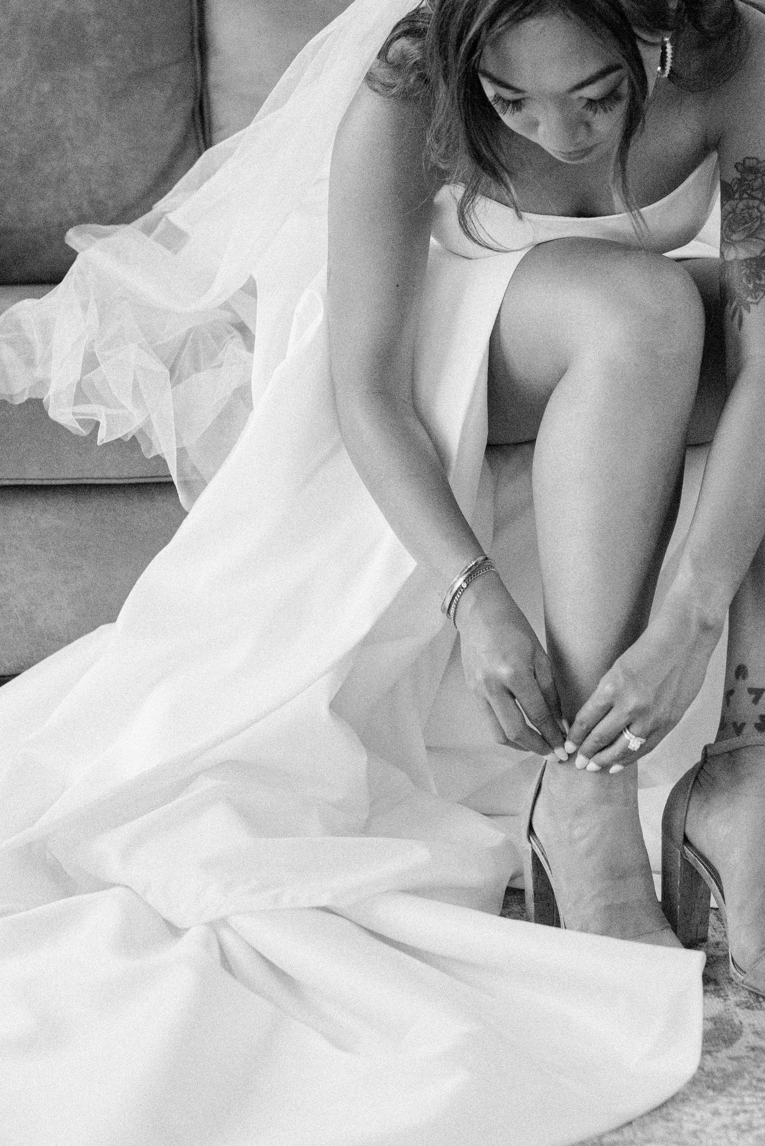 A series of close-up shots showing the bottom hem of a white wedding dress being adjusted on a floor.