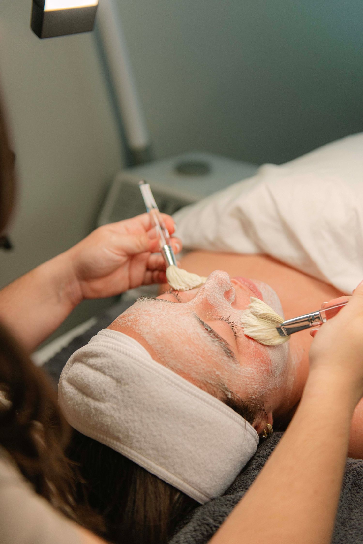 Spa facial treatment with cotton pads and professional tools on client.