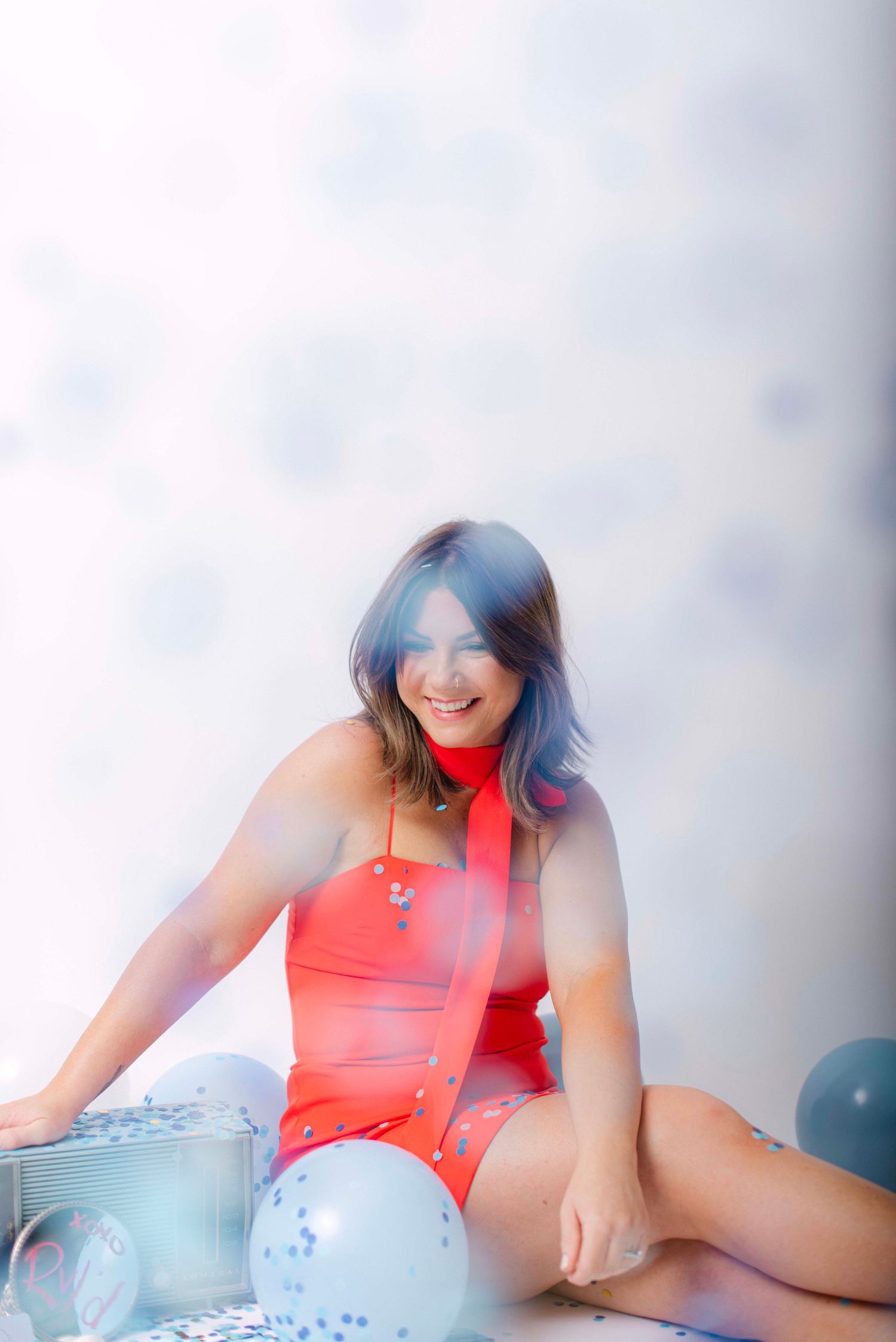 Playful portrait session with balloons featuring coral colored clothing.