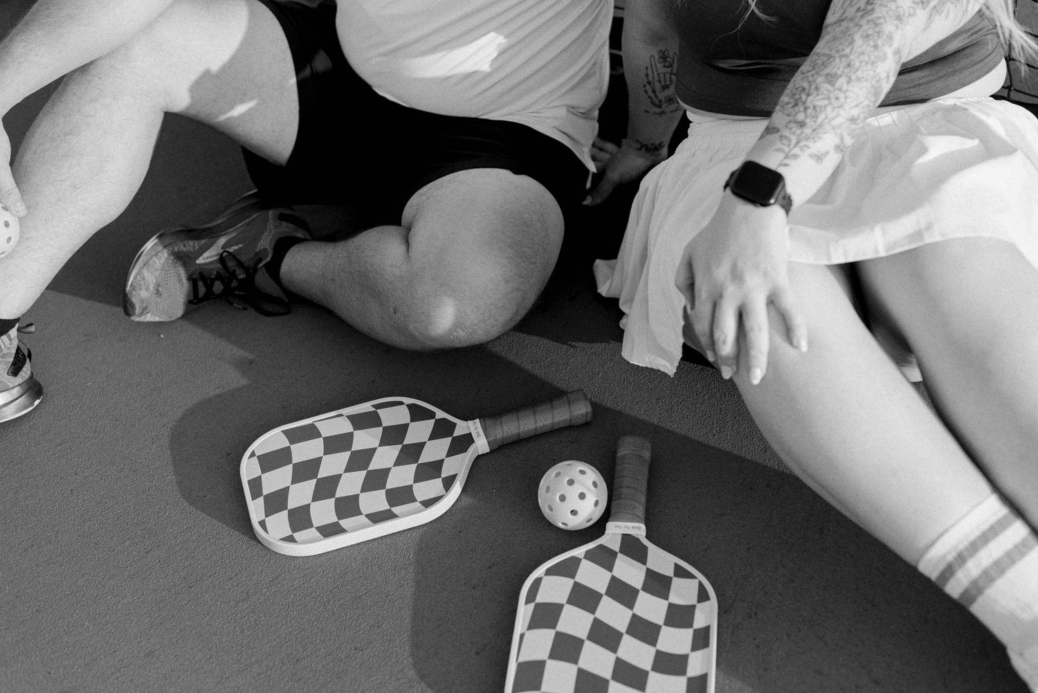 A series of black and white photographs showing hands playing a checkerboard pattern game.
