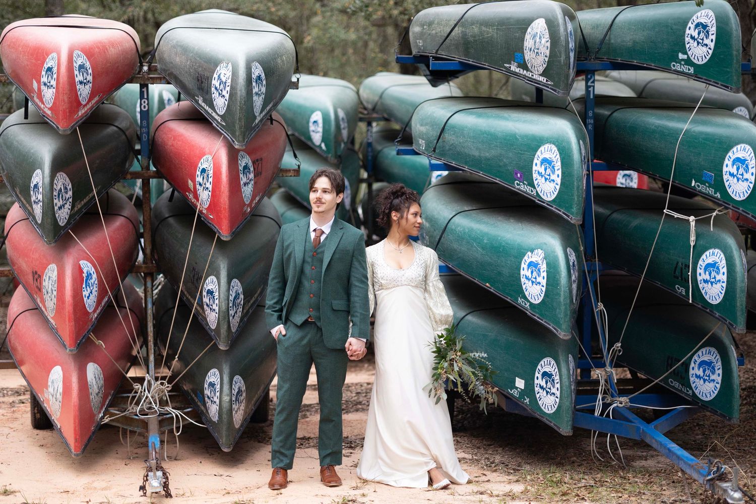 Row of vintage racing cars lined up outdoors at a wedding venue.