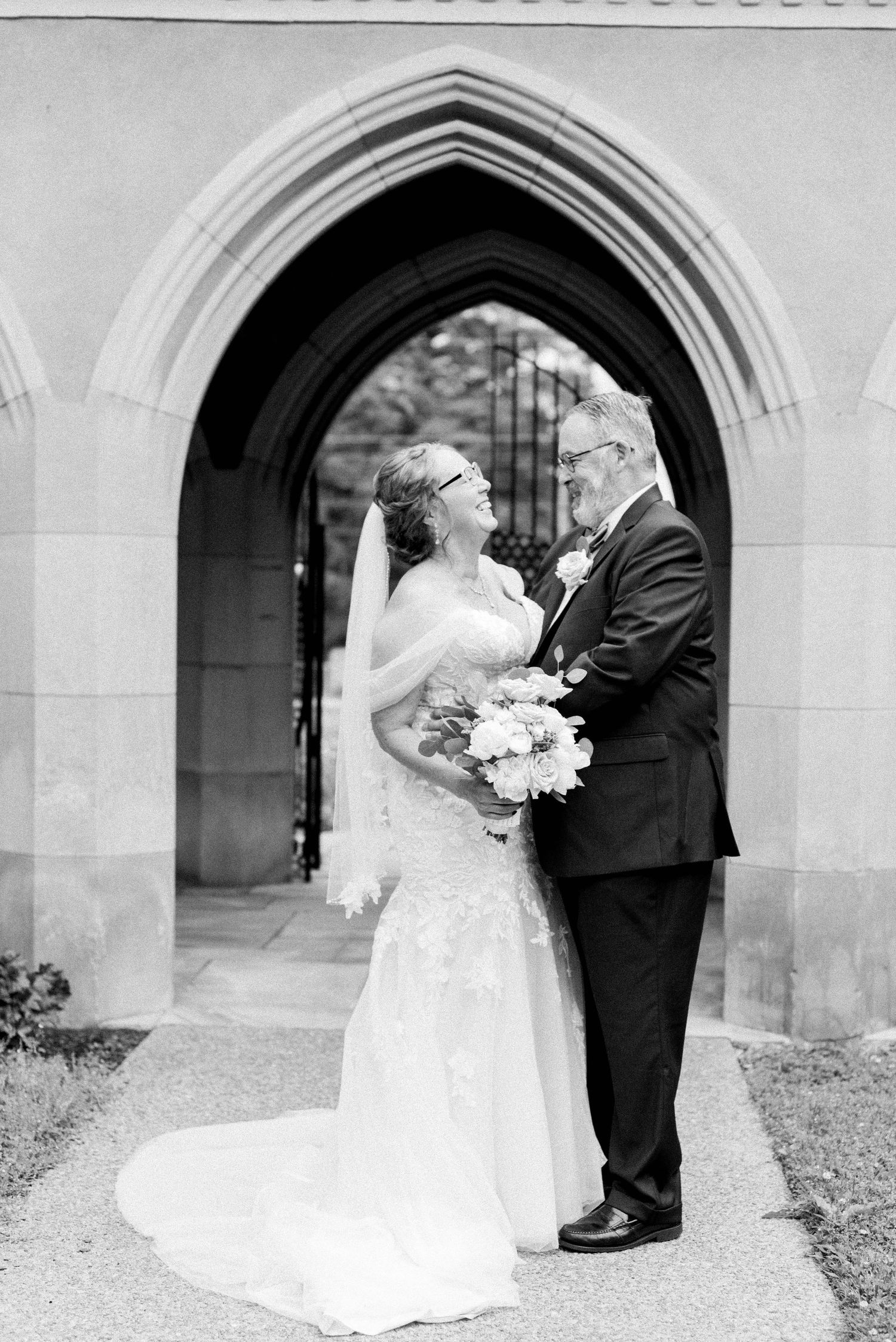 Black and white wedding photos under stone archways showing romantic moments.