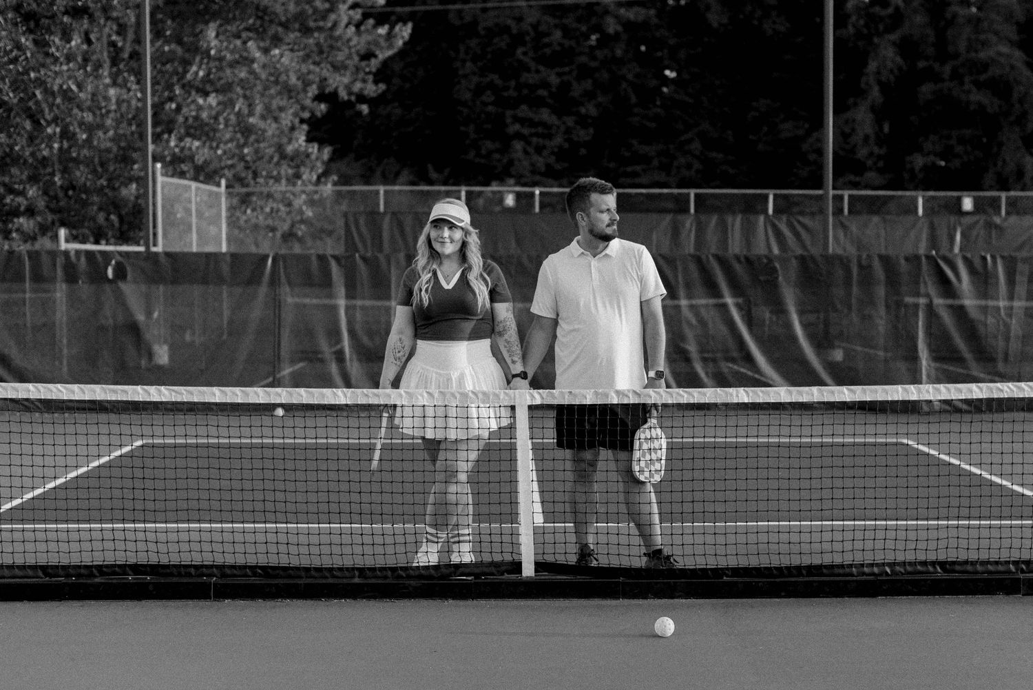 Tennis players practicing serves and volleys on outdoor courts during a training session.