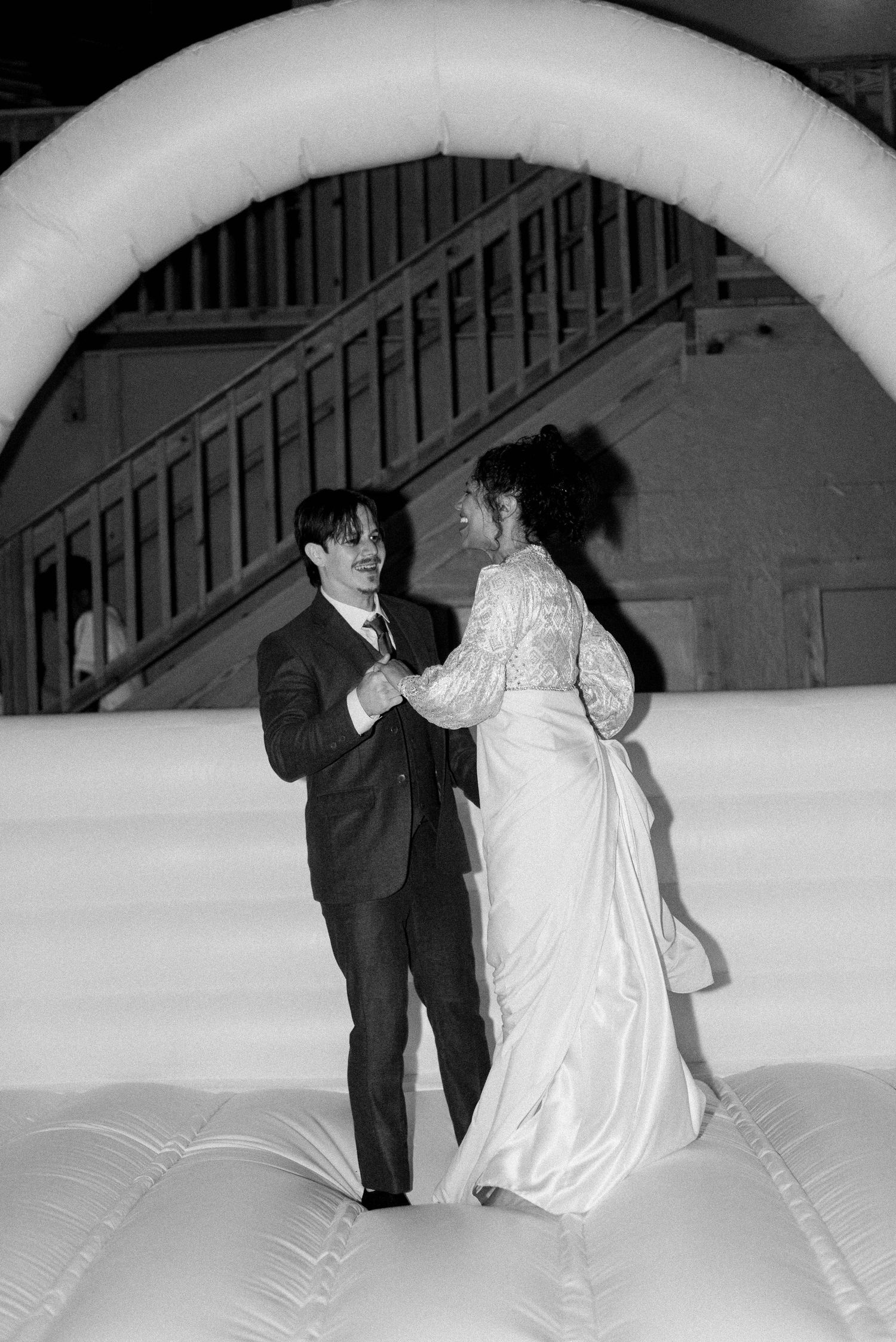 Black and white sequence of a couple dancing under an illuminated arch.