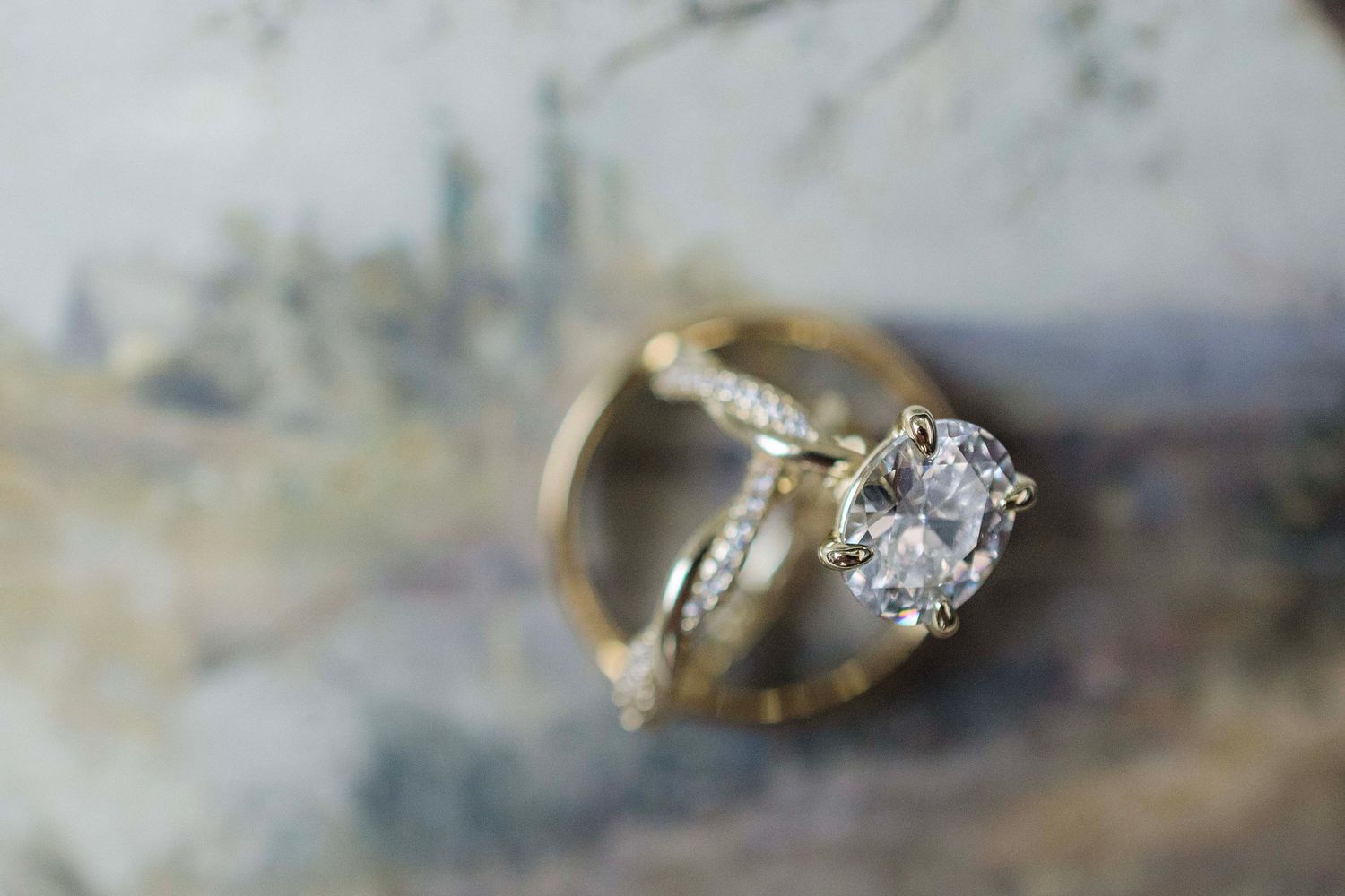 A collection of vintage and antique rings displayed on a light gray surface showing various styles and gemstones.