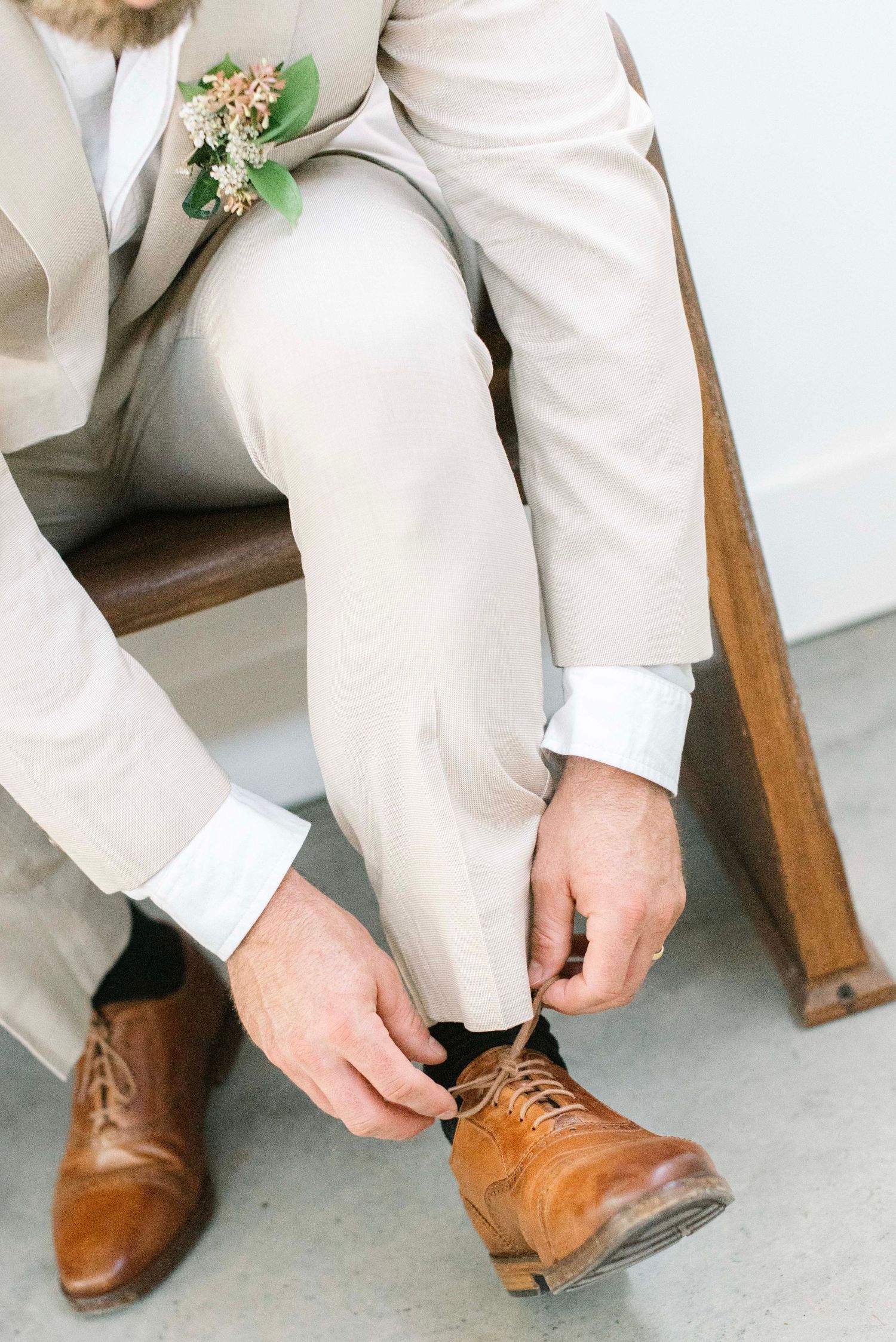 A sequence showing brown leather dress shoes being put on with light colored pants.