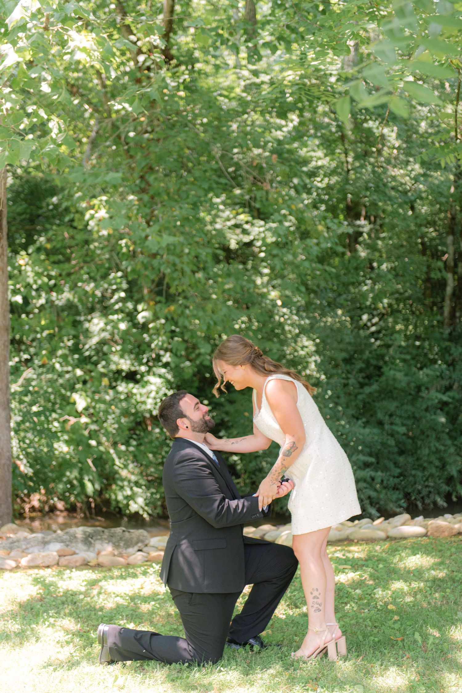 A couple shares playful moments in a garden setting during a romantic outdoor photo session.