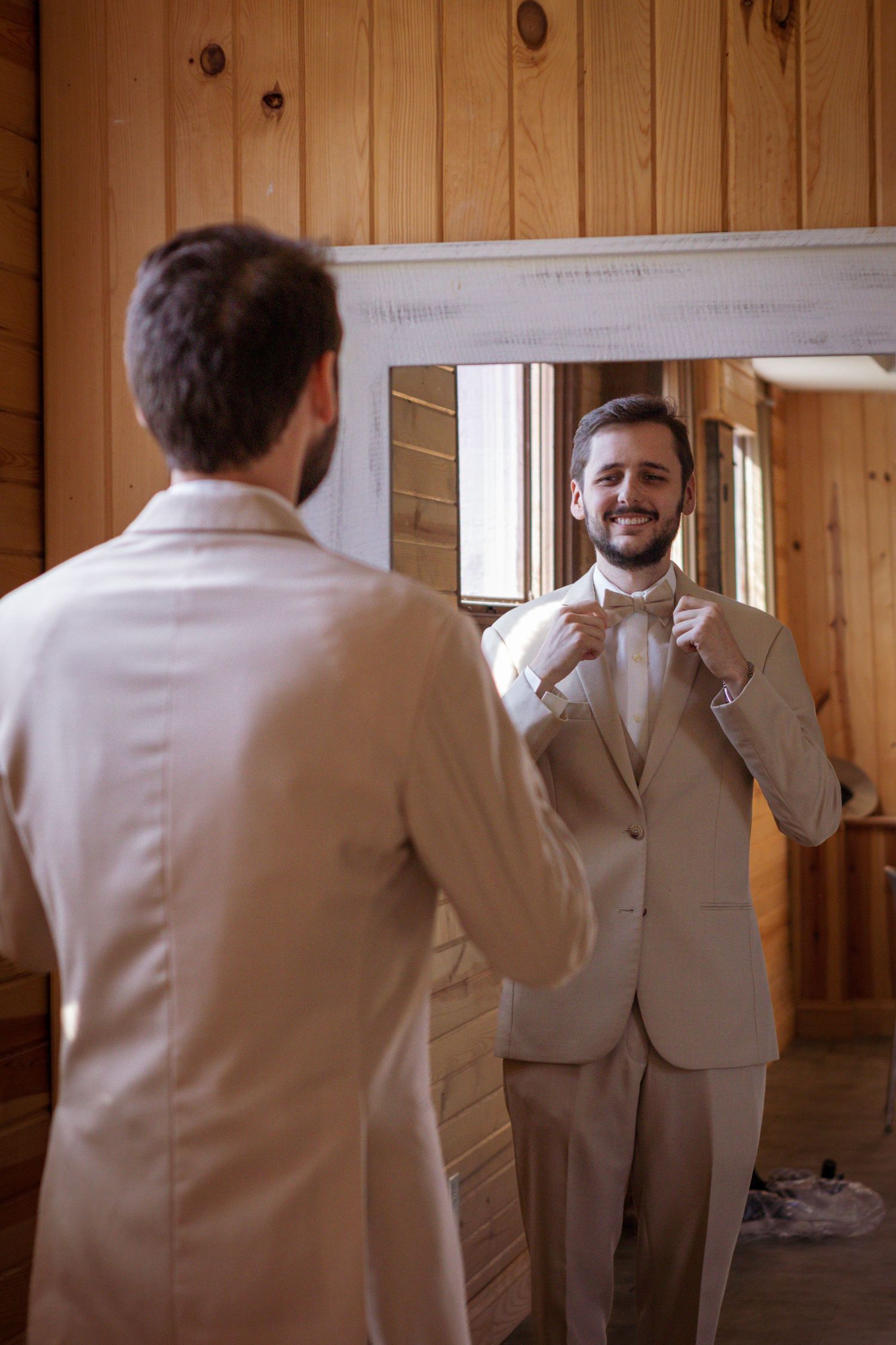 Groom smiling in a mirror