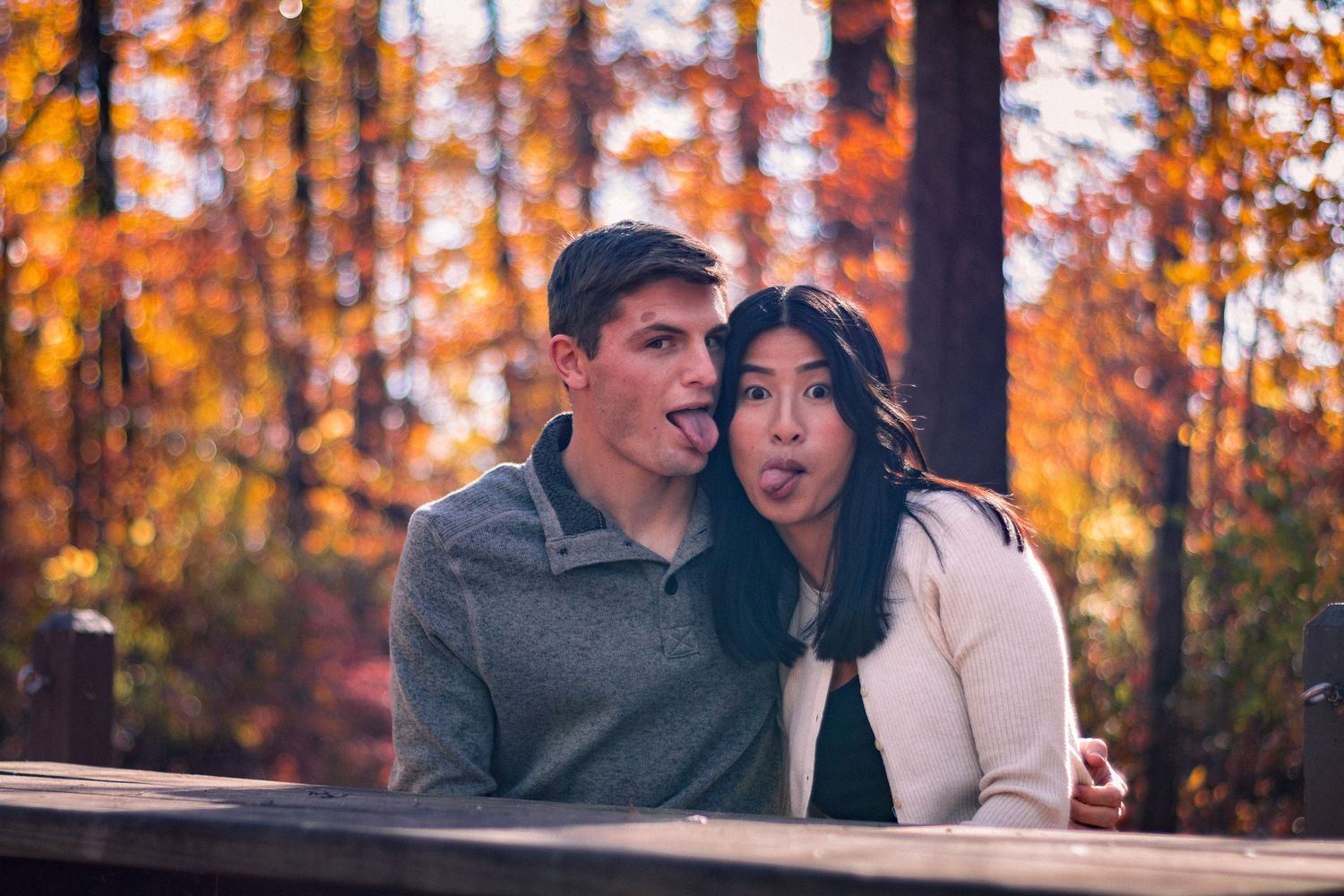 Couple in autumn setting with tongues out