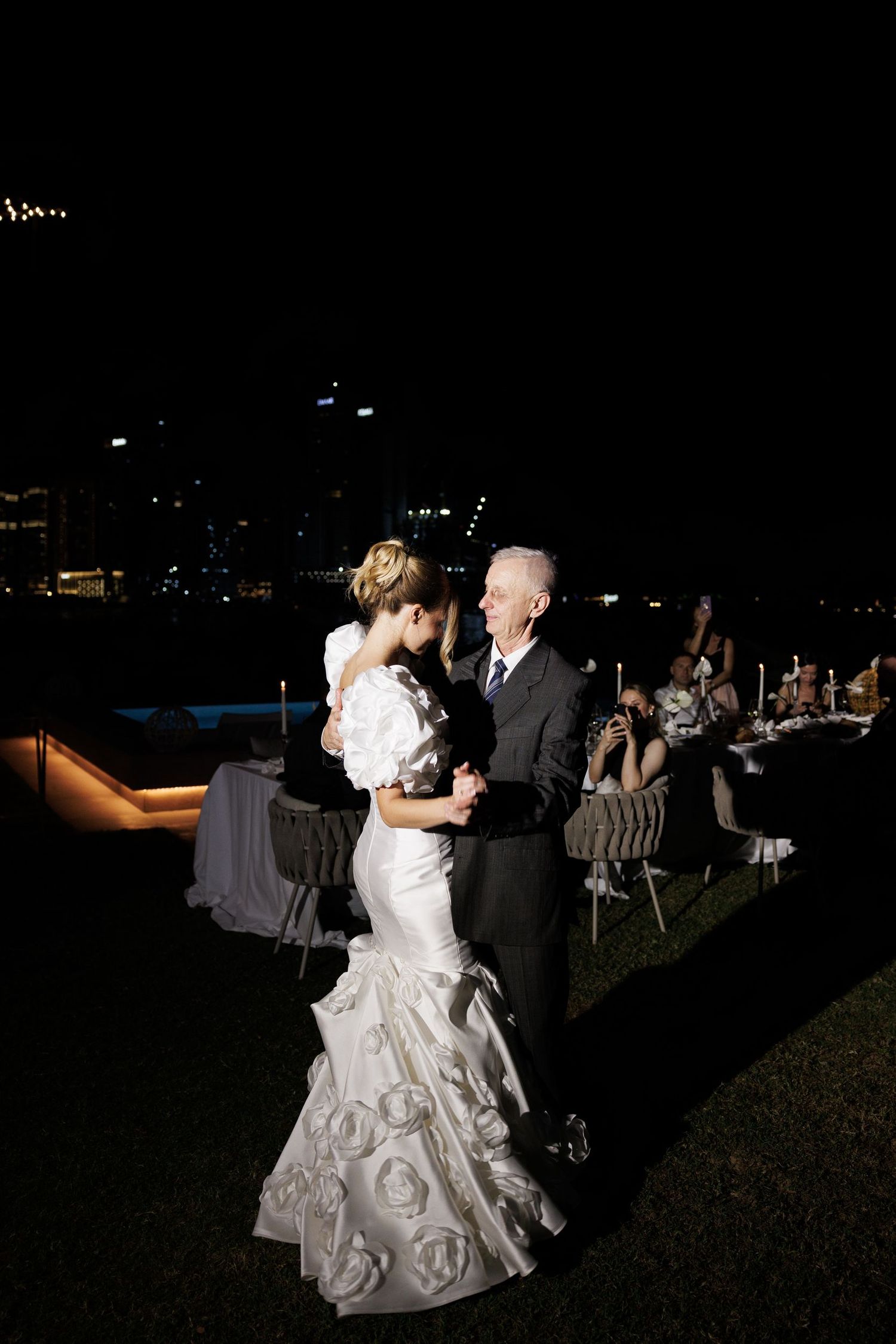 Couple dancing at outdoor evening wedding reception.
