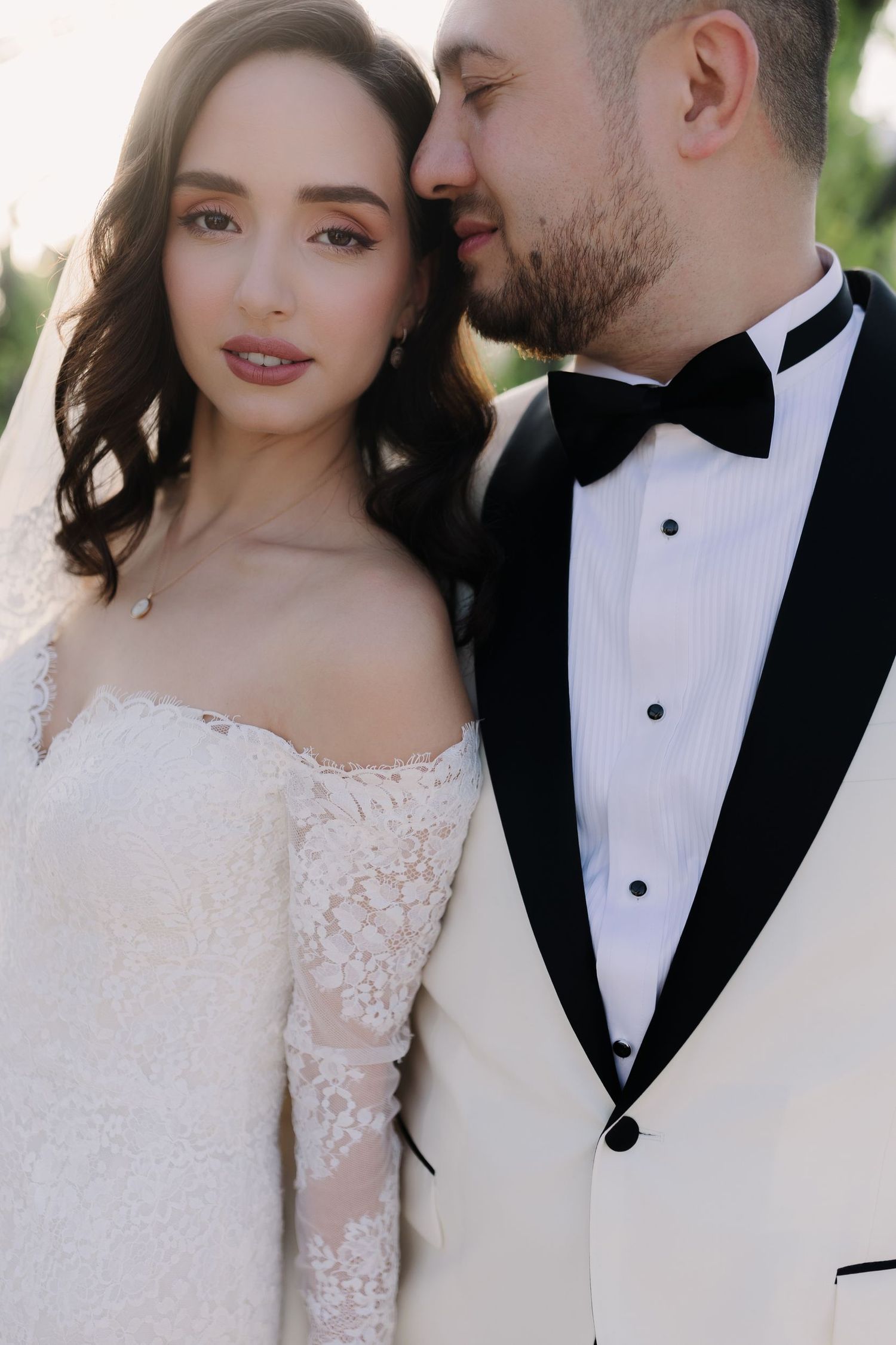 Intimate wedding portrait with elegant white dress and black tuxedo.