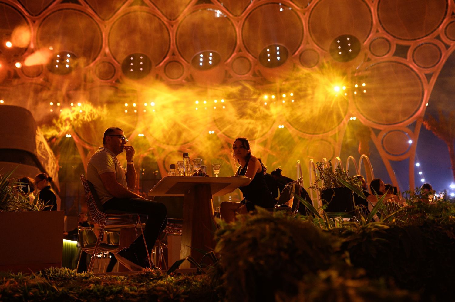Concert venue with golden lighting and honeycomb pattern ceiling creates atmospheric ambiance.