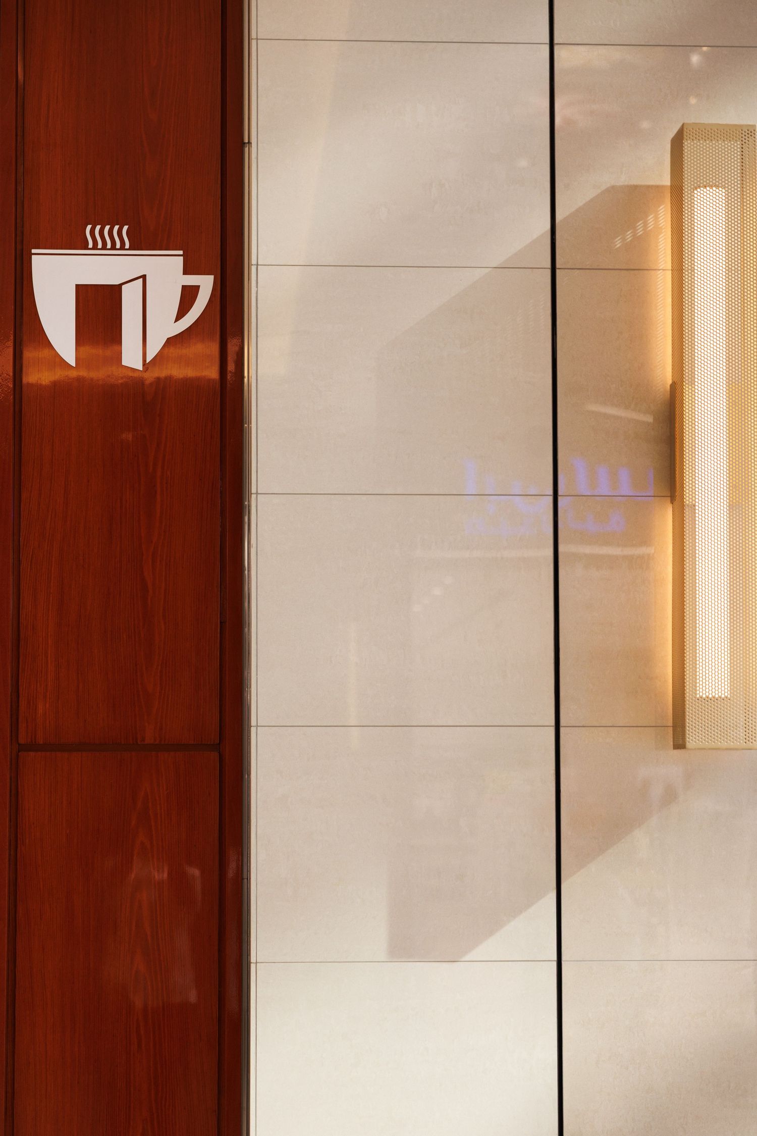 Modern interior hallway with wood panels and illuminated wall sconces.