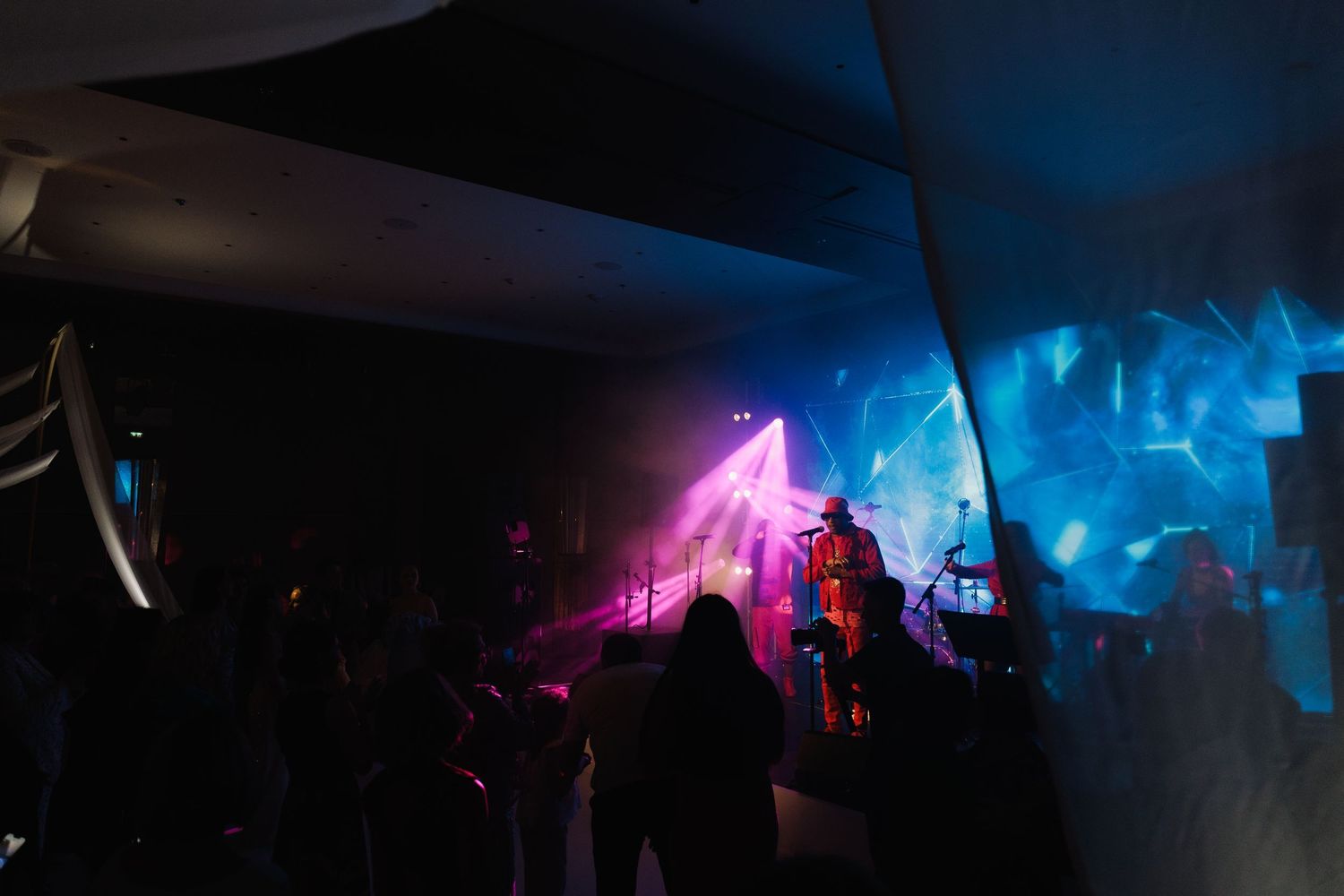Concert venue with dramatic lighting creating a moody atmosphere.