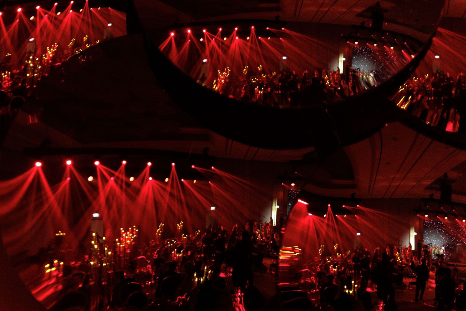 Concert venue illuminated with dramatic red lighting and stage effects.