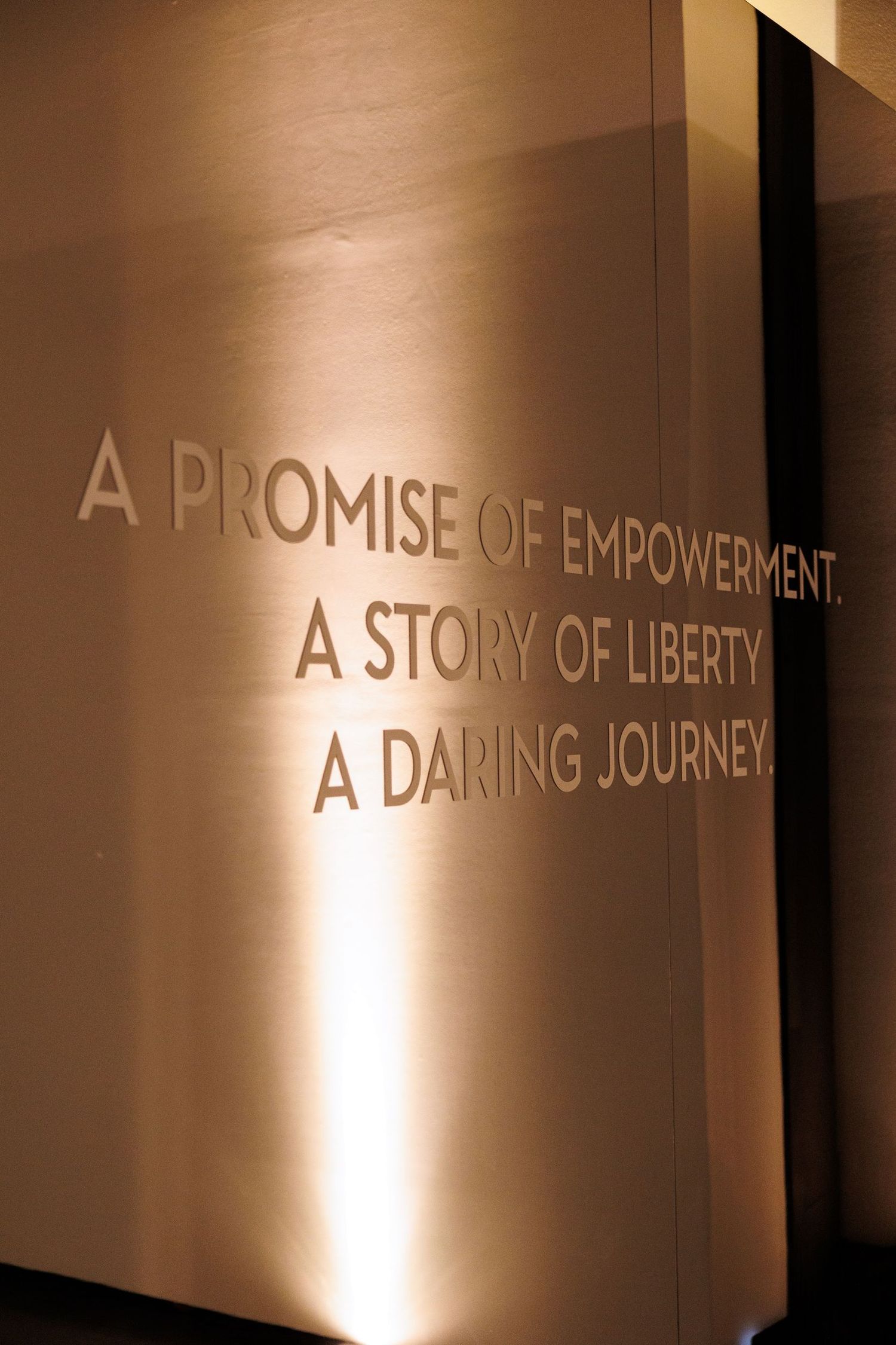Illuminated wall text displaying inspiring phrases about empowerment and liberty.