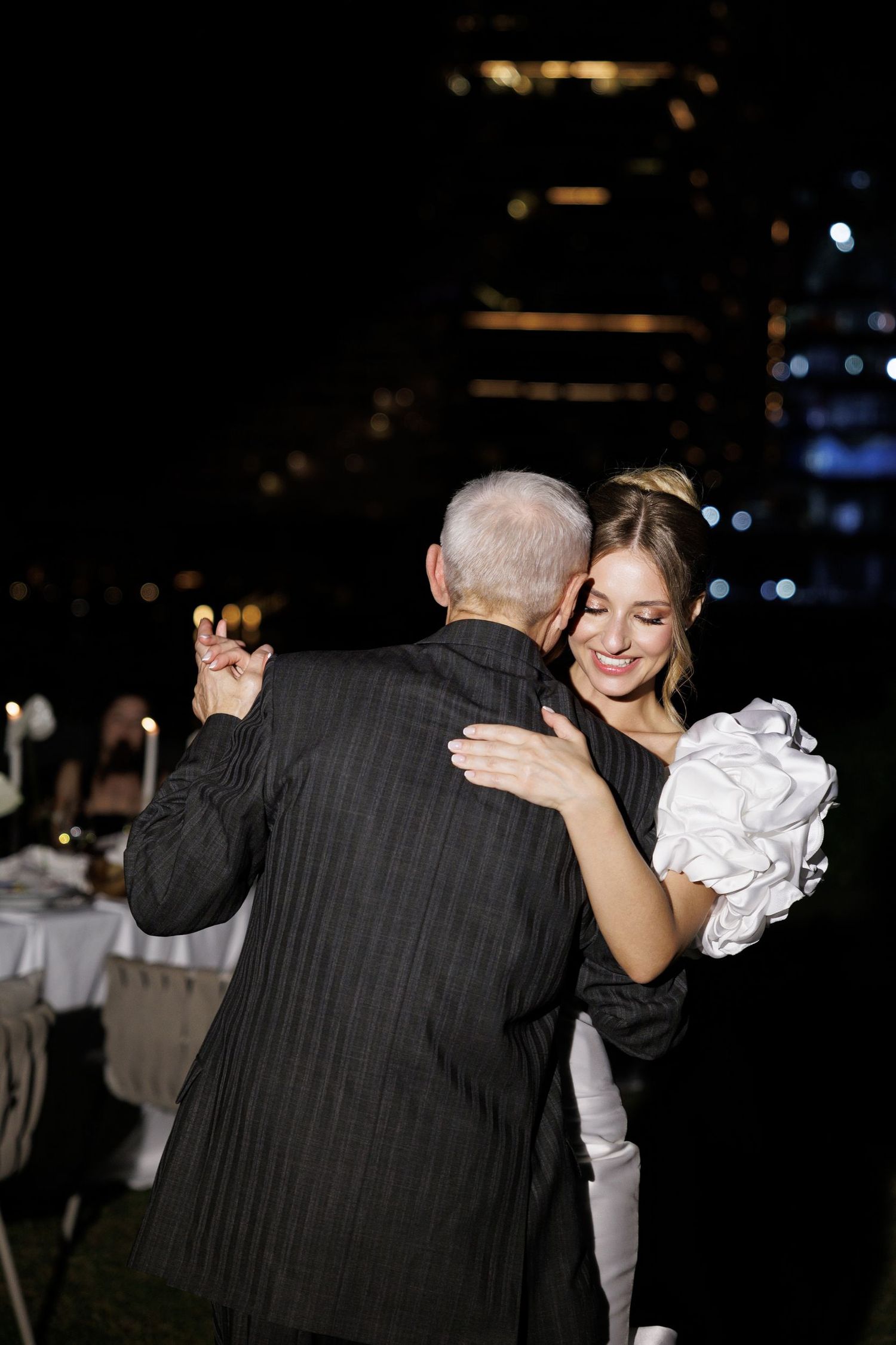 A tender dance moment captured at a wedding reception in low light.
