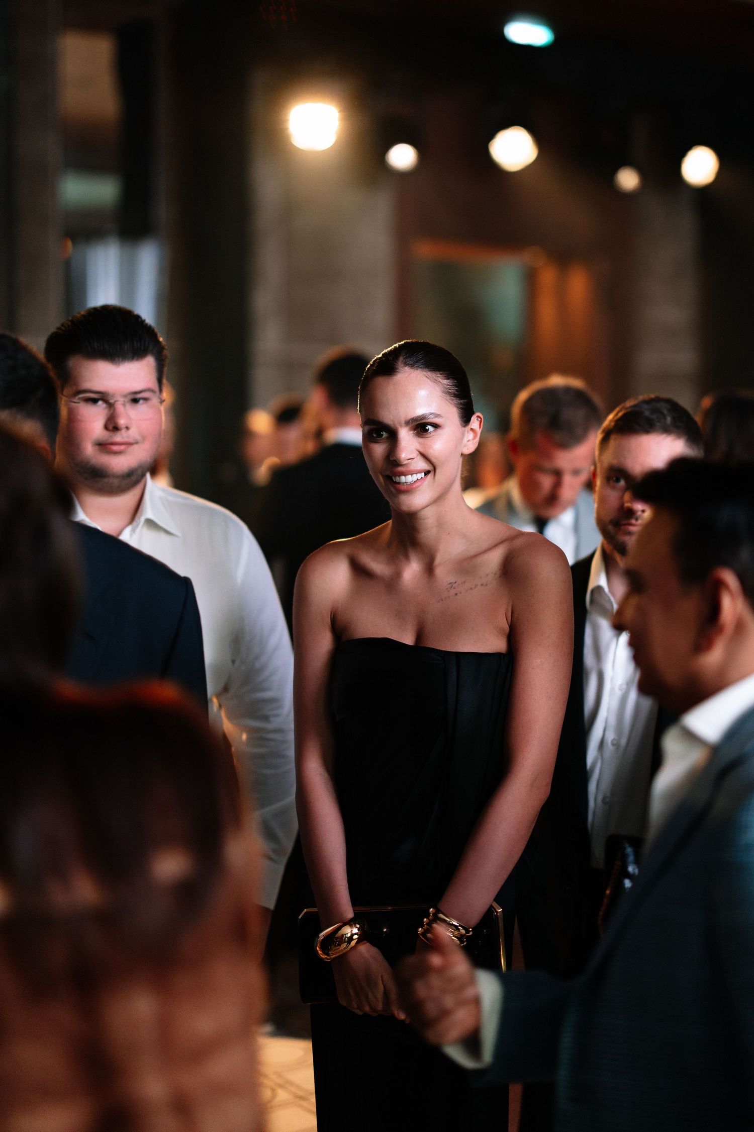 A sequence of candid nighttime party photos showing guests interacting and dancing in dim lighting with bokeh effects.