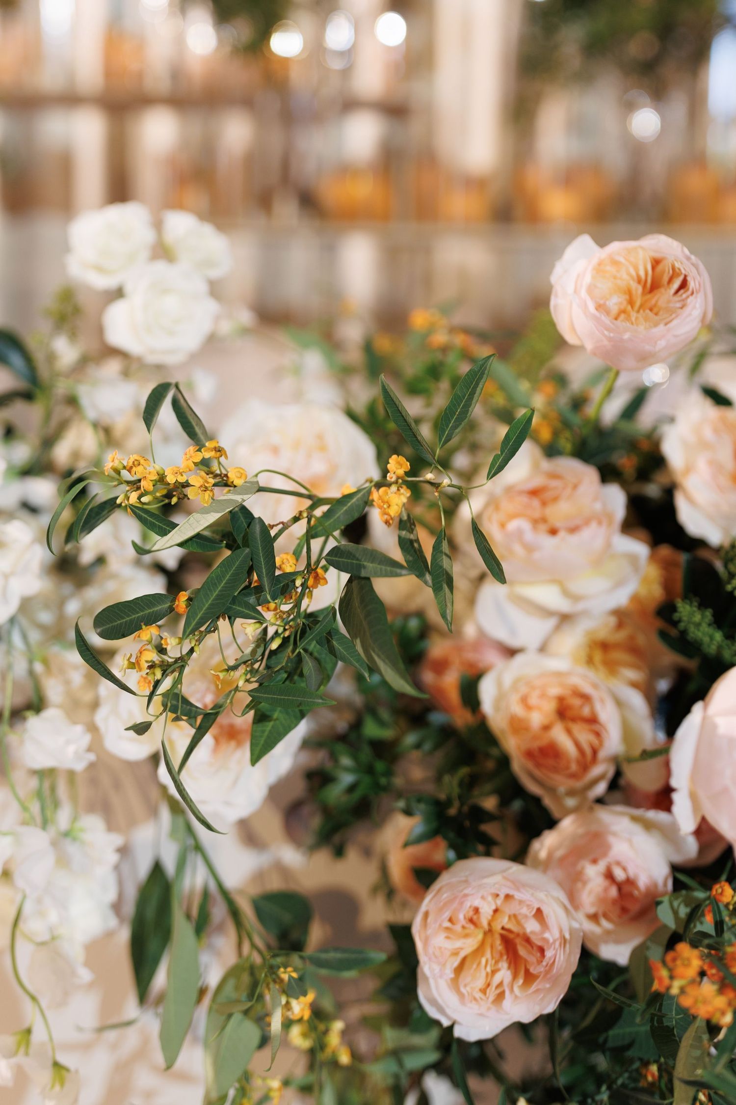 Delicate peach garden roses and green foliage create an elegant floral arrangement.