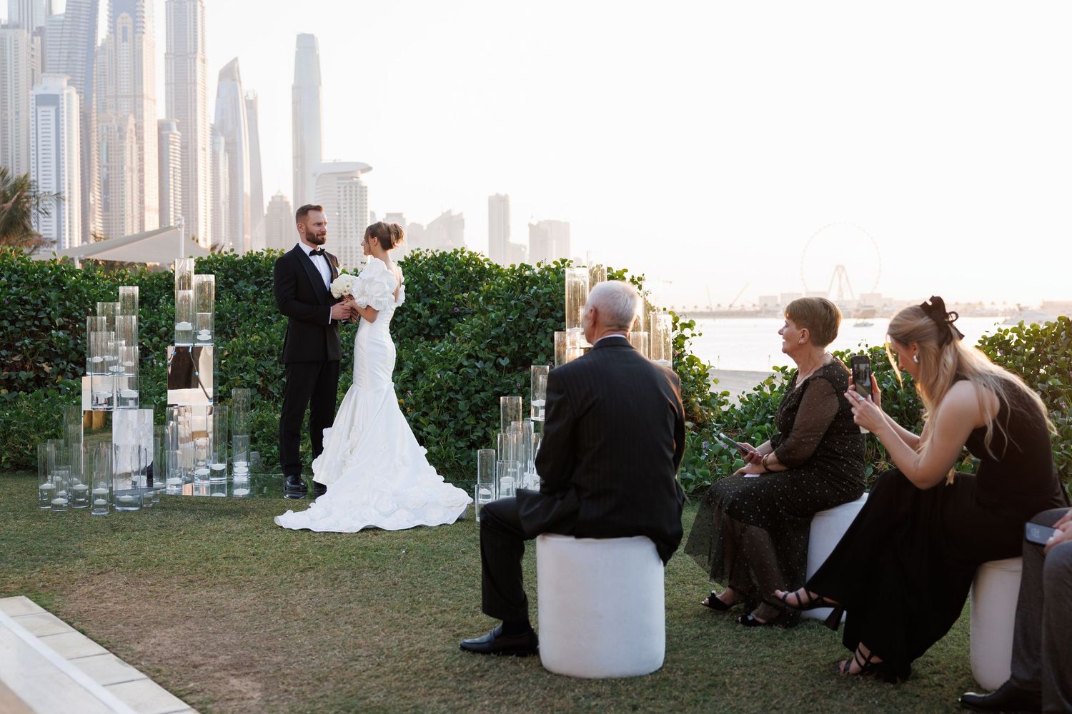 Wedding celebration on a rooftop terrace with city views and decorative lighting.